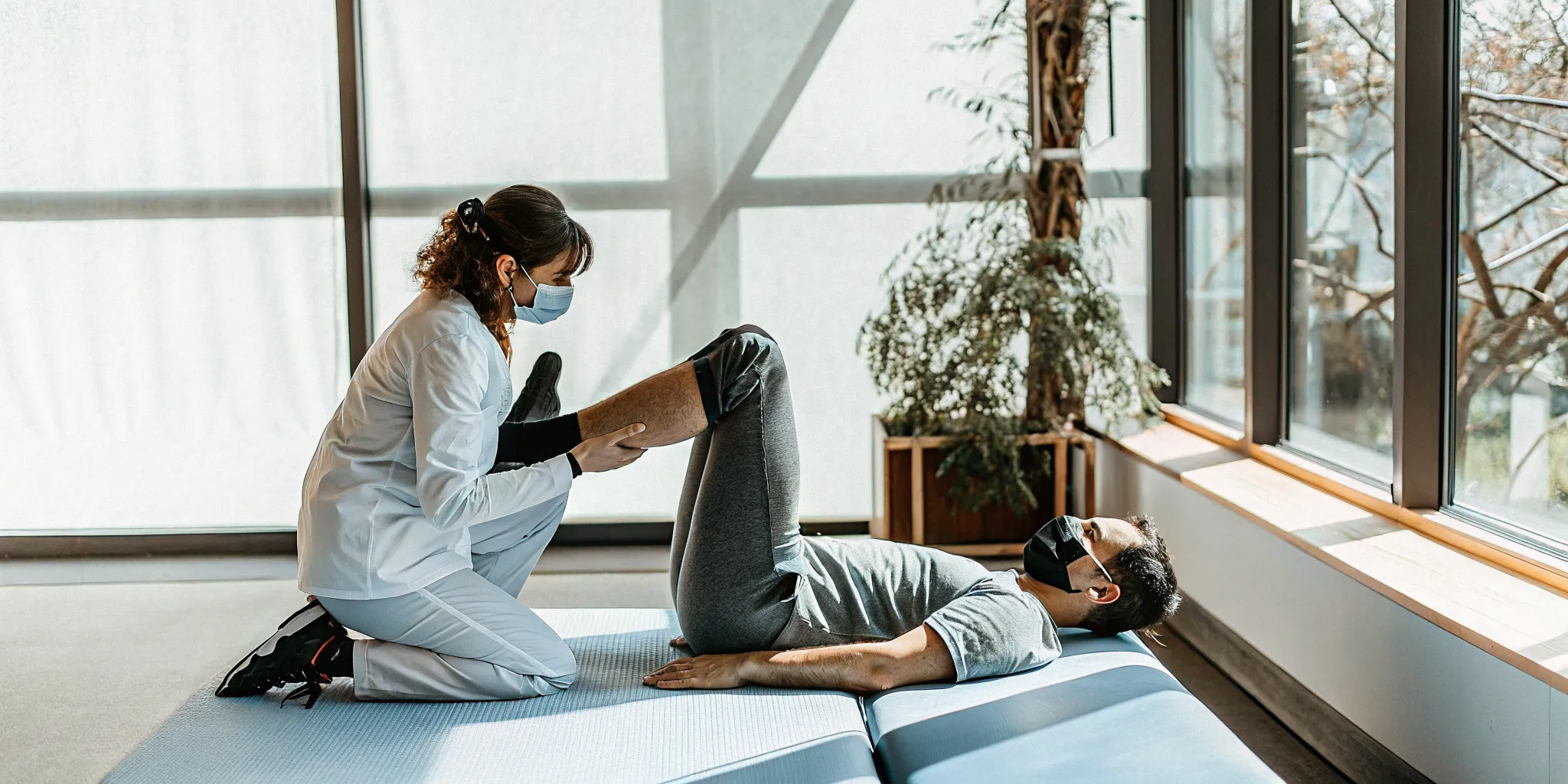 Physical therapist guiding a patient through a controlled ACL rehabilitation strength exercise