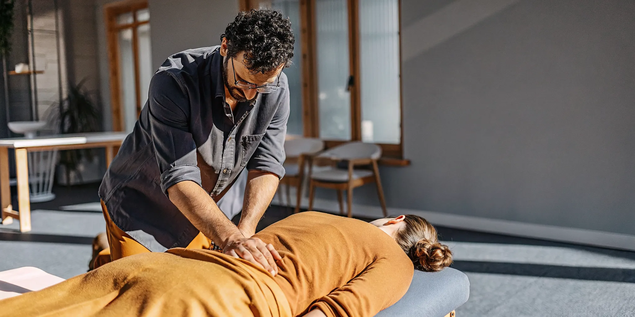 Chiropractor performing a gentle spinal adjustment on a patient in a modern Brooklyn clinic