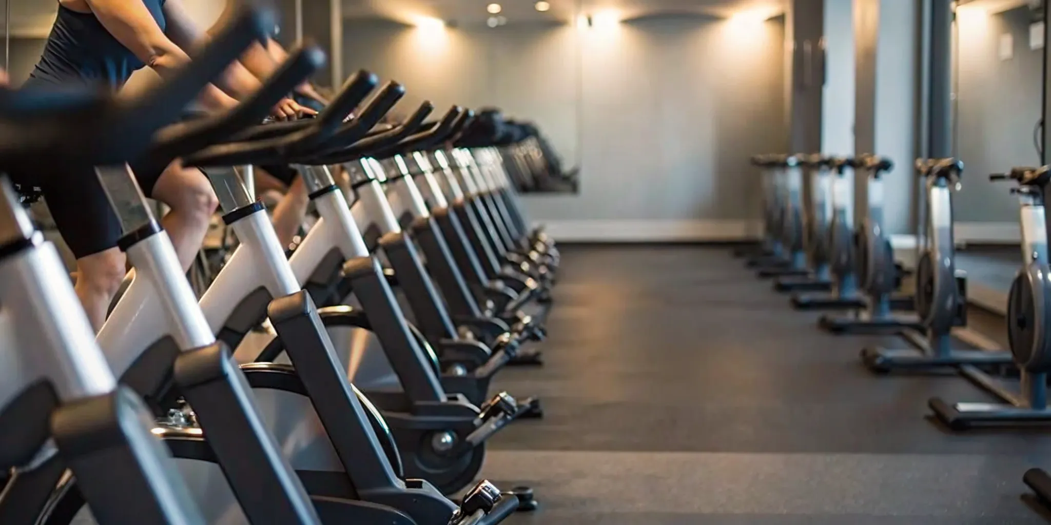 Indoor cycling bikes in a modern Flatiron fitness studio with riders in motion