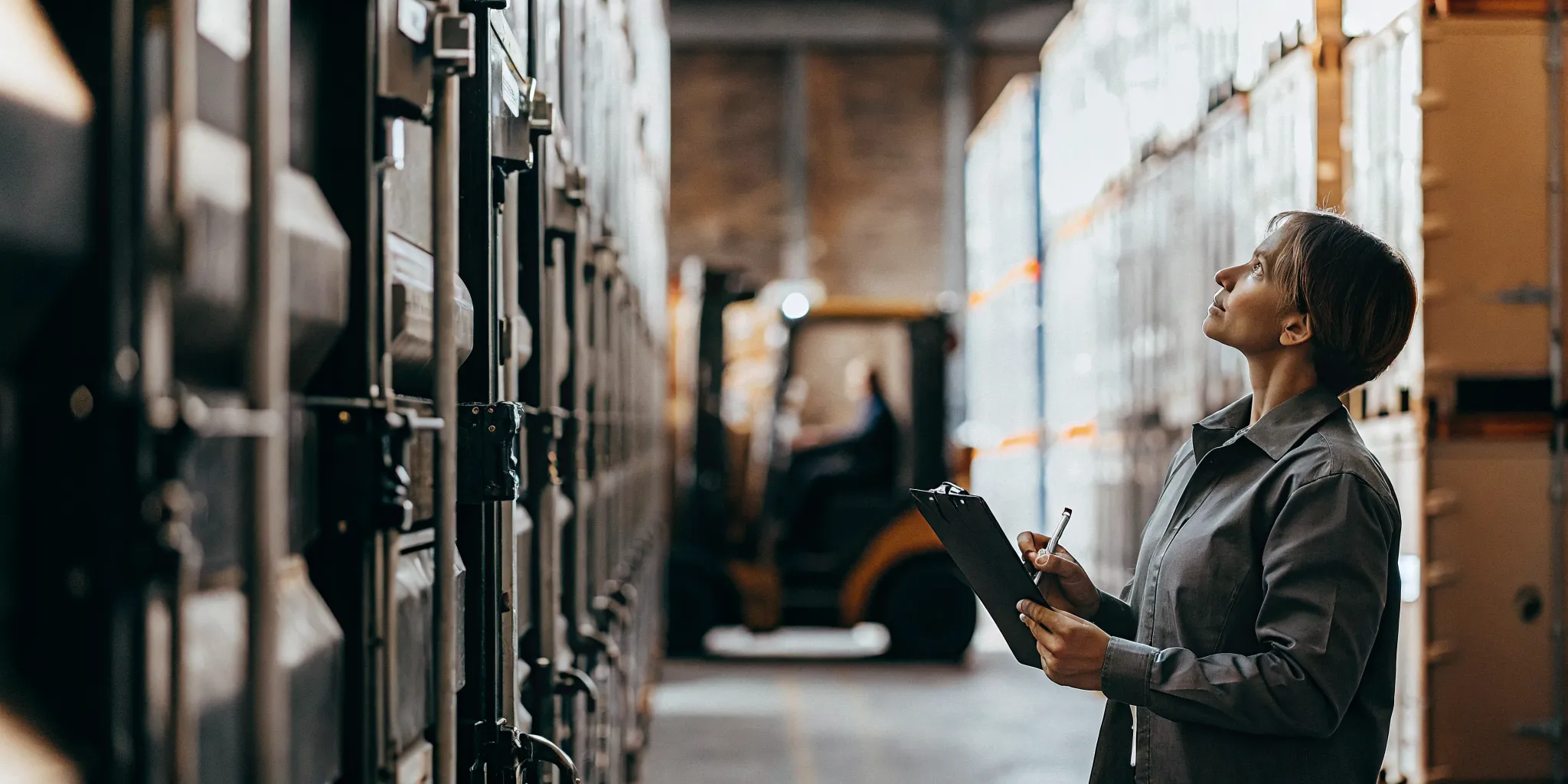 Logistics warehouse manager inspecting shipping containers secured with high-security seals during a supplier validation process