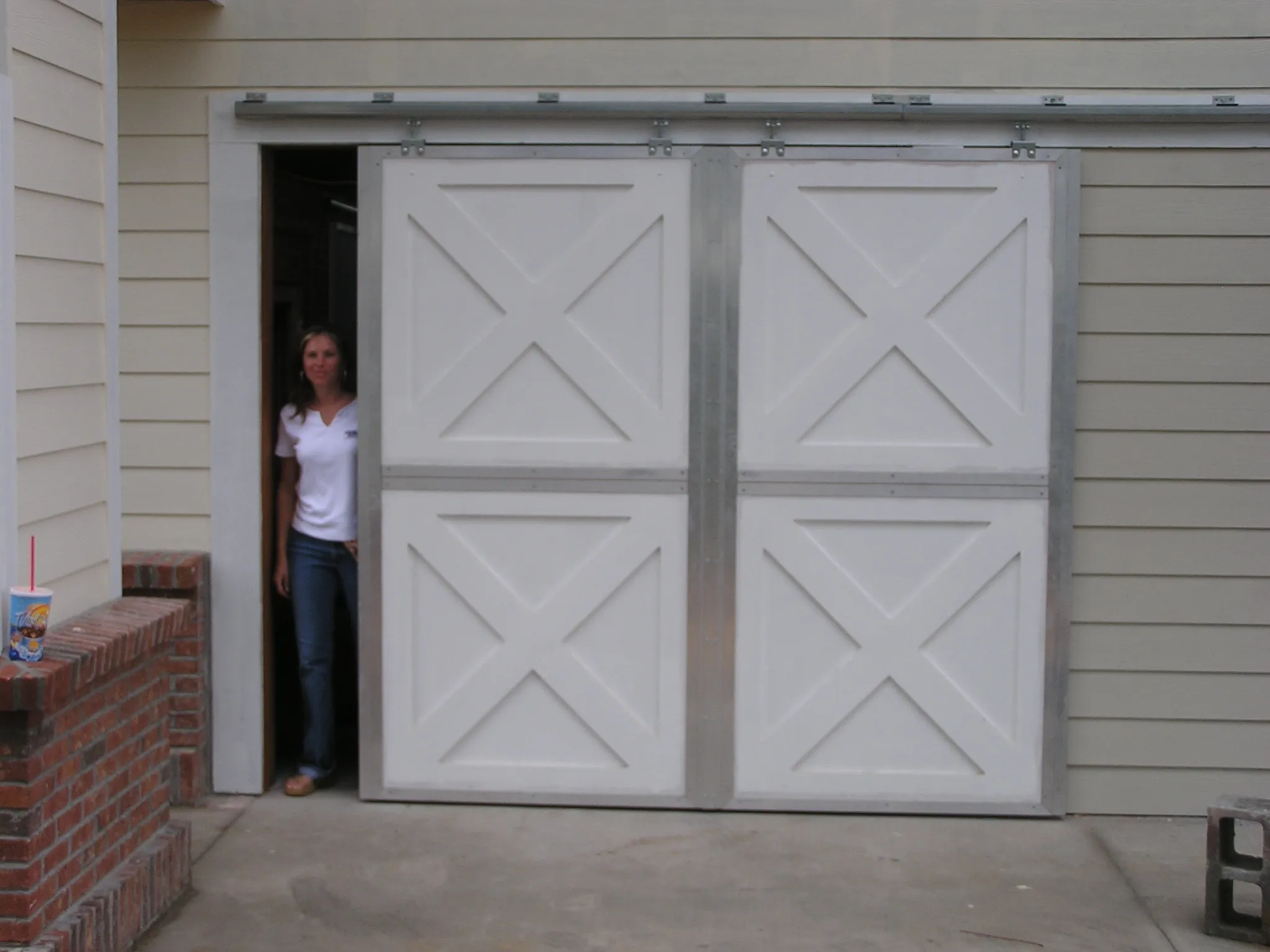 Installed sliding aluminum tack room doors with center astragal in a working horse barn