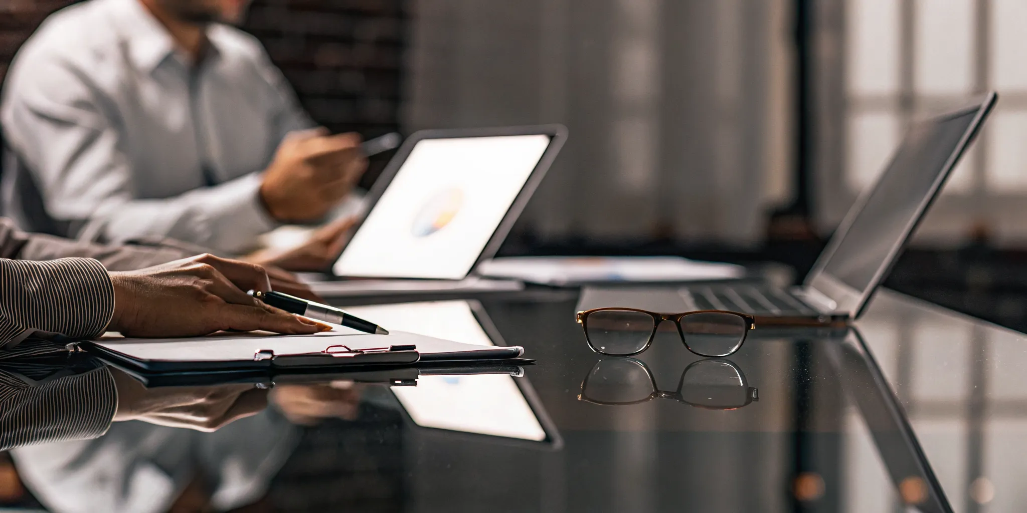 Team analyzing data on laptops for insurance claims performance management.