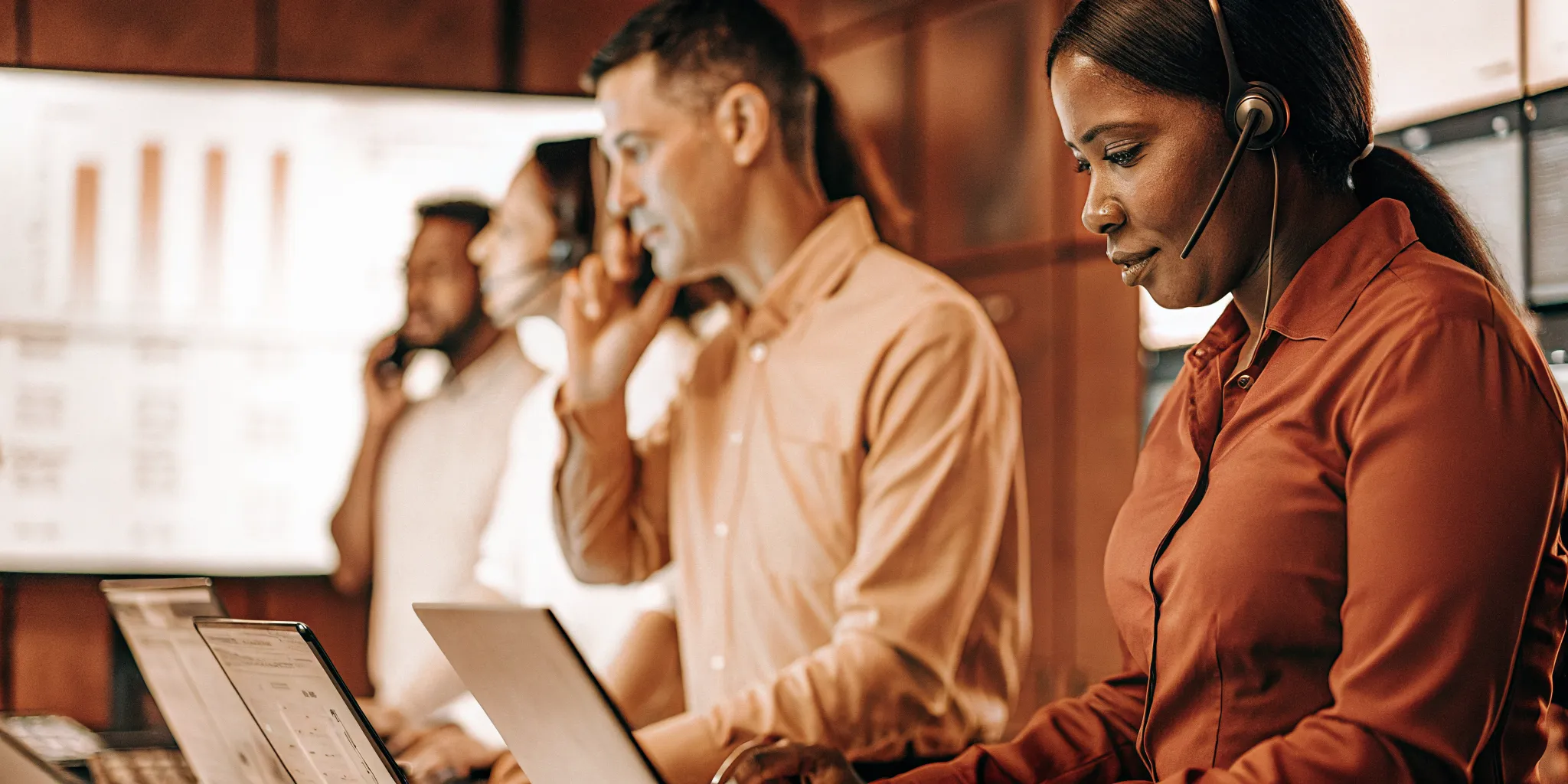A modern enterprise contact center operations floor with dashboards