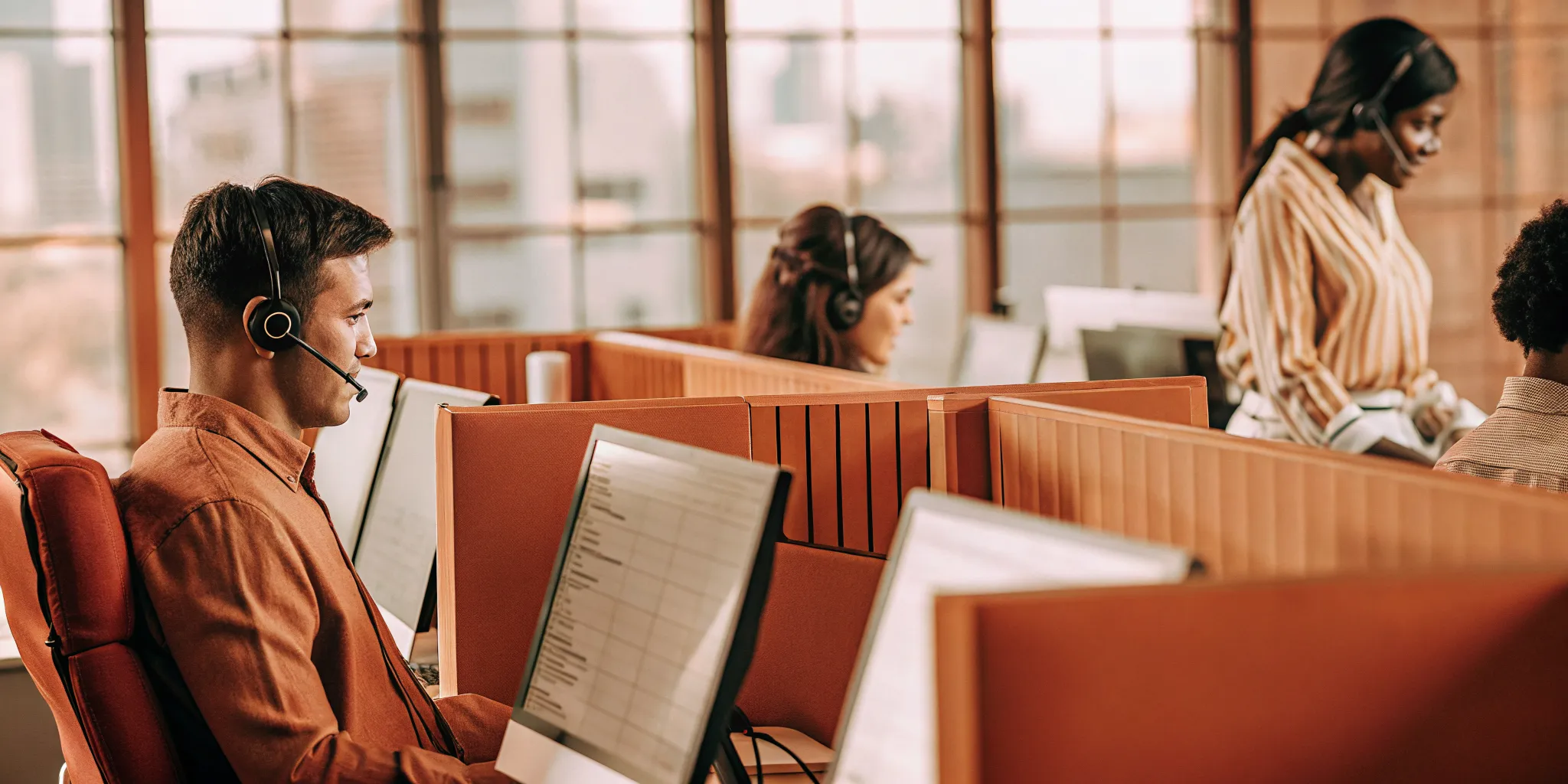 Call center tech trends in action with agents using modern computers and headsets.