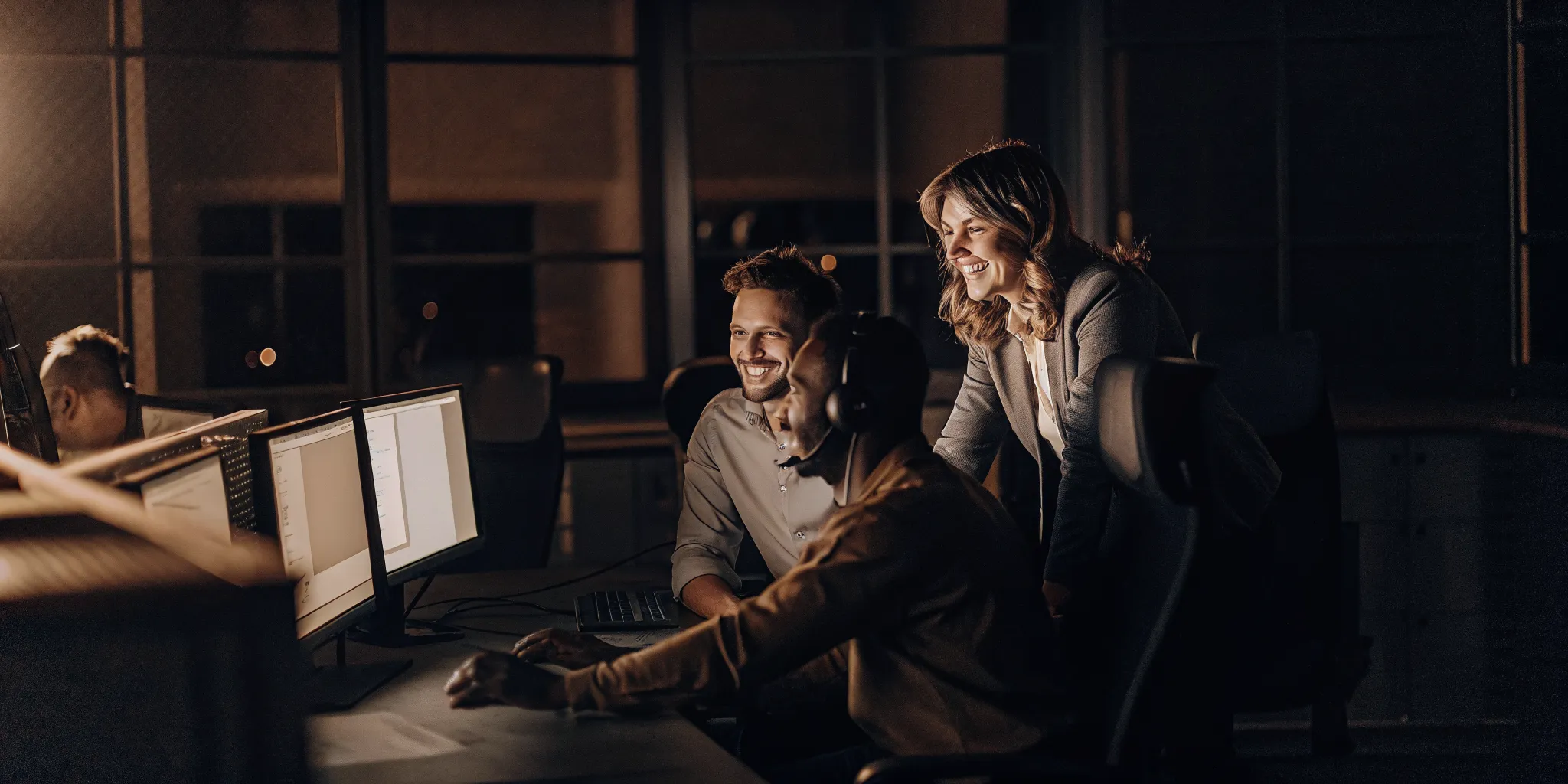 Contact center team collaborating in a modern workspace with engaged employees discussing performance data