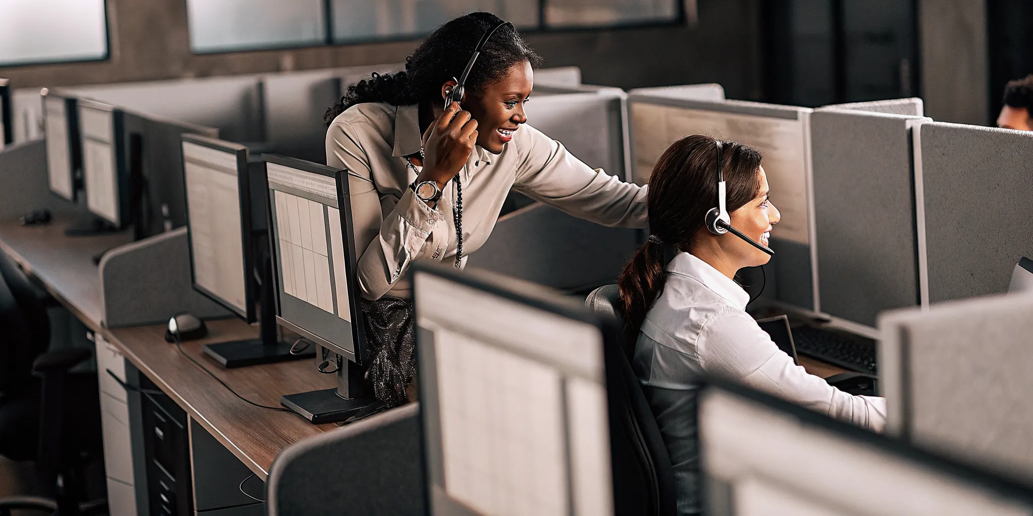 Manager coaching a contact center agent in a professional office environment