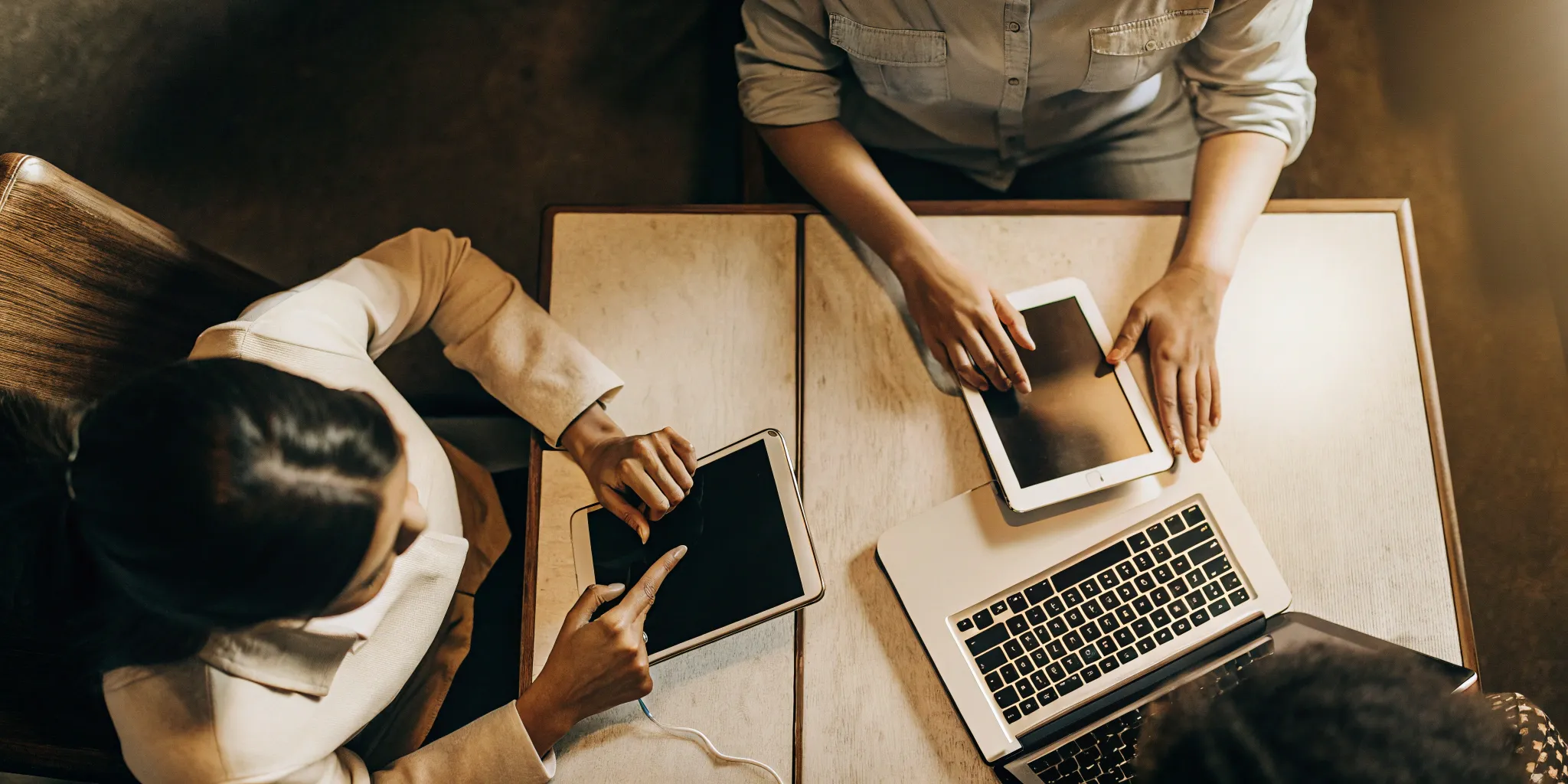 Two agents use a knowledge base on a laptop and tablets to improve their performance.