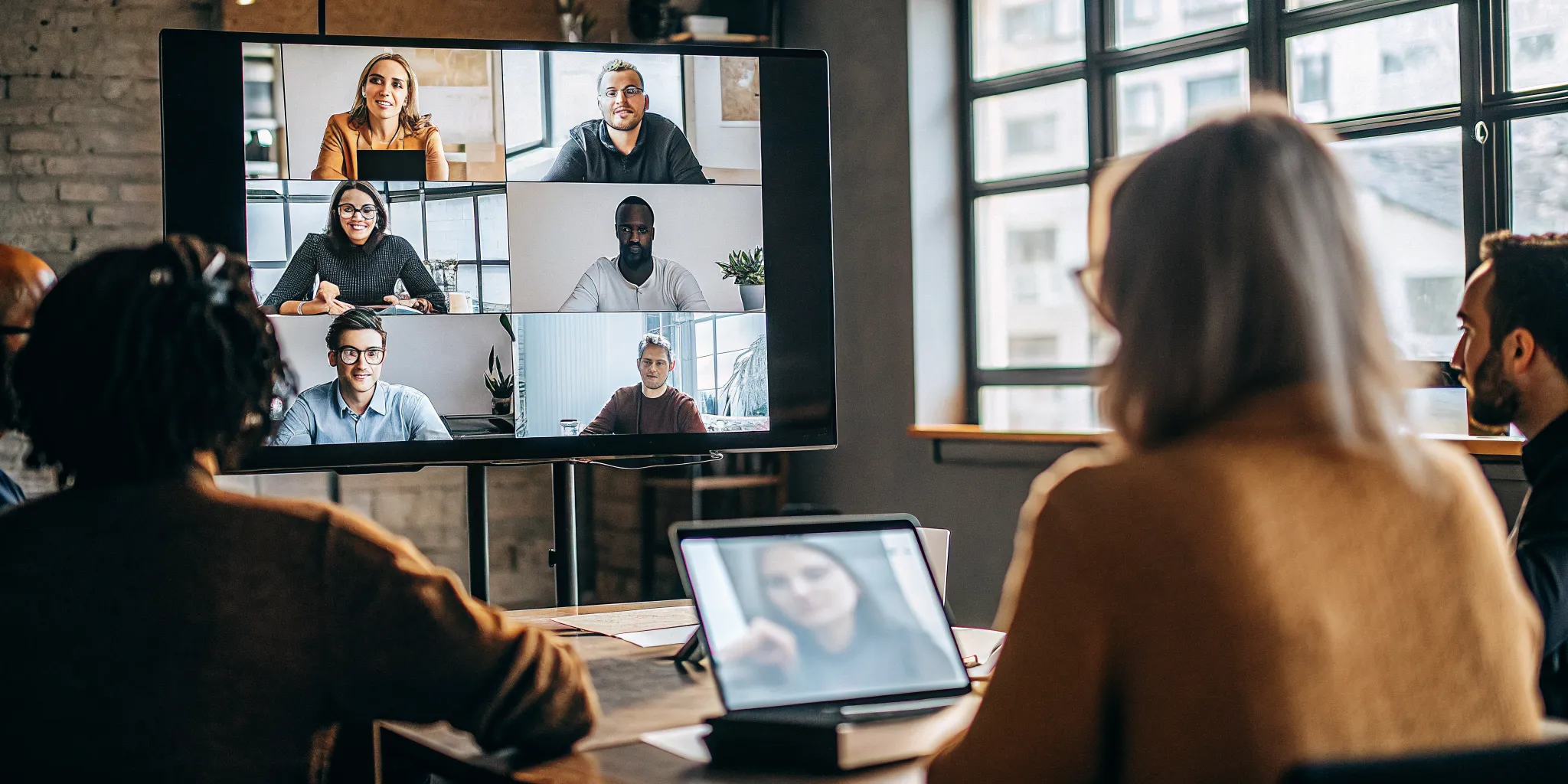 Operations leaders coordinating coaching across a hybrid contact center team with a remote agent on video
