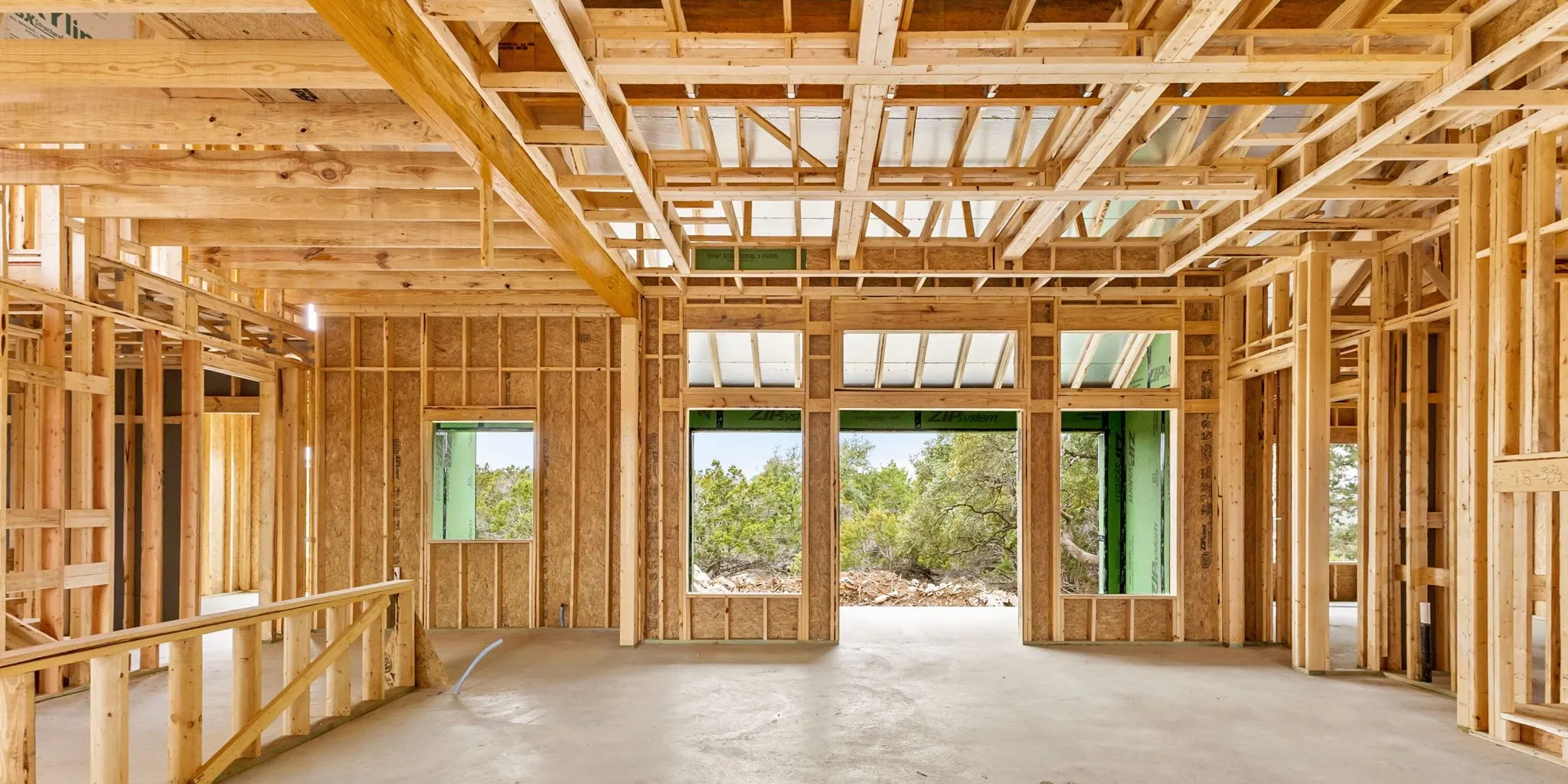 Calculating the cost to build a house in Texas Hill Country with blueprints and a laptop.