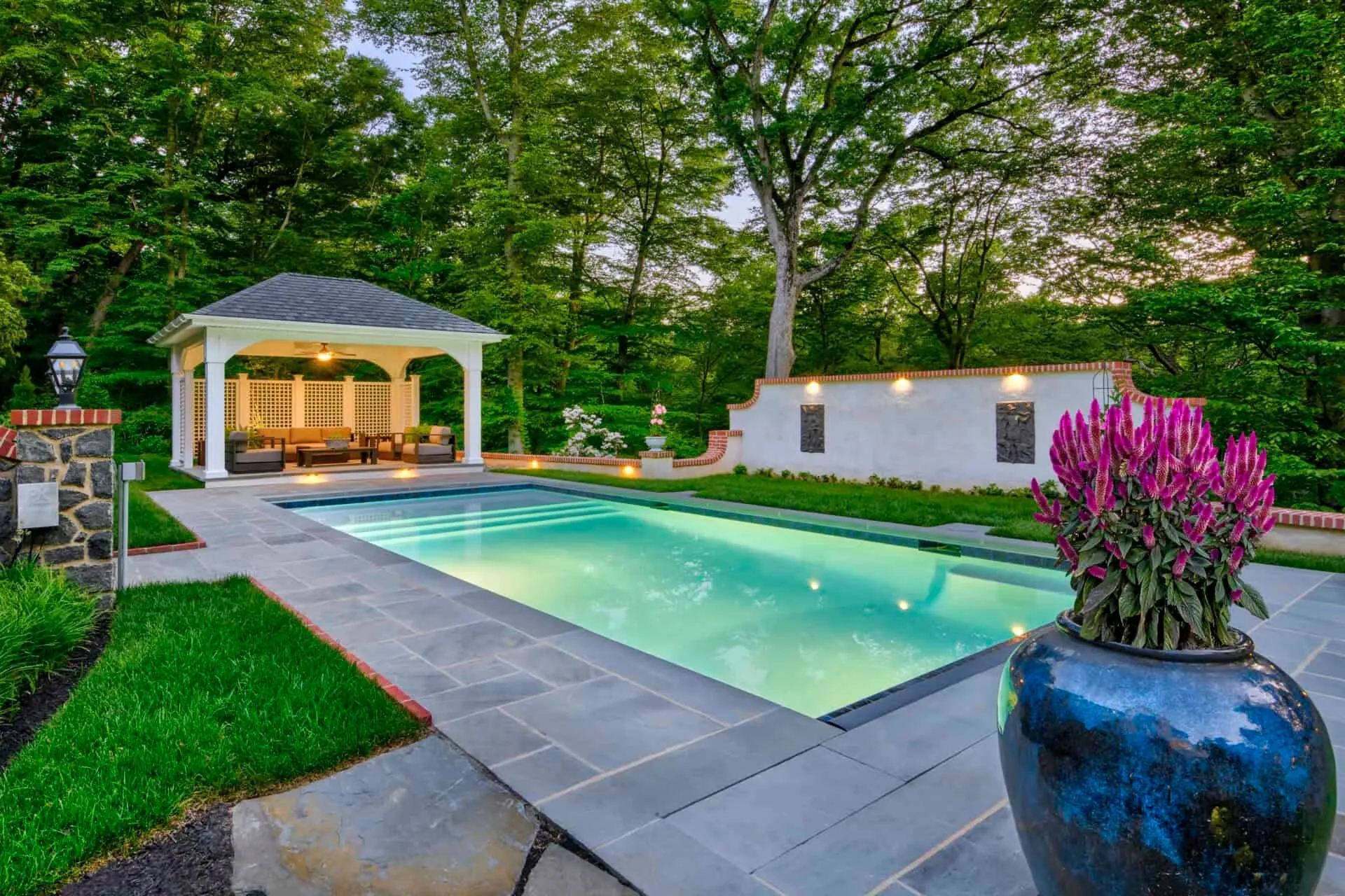 Custom gunite pool with waterfall feature and natural stone surround designed by Pronto Pools in Delaware Valley