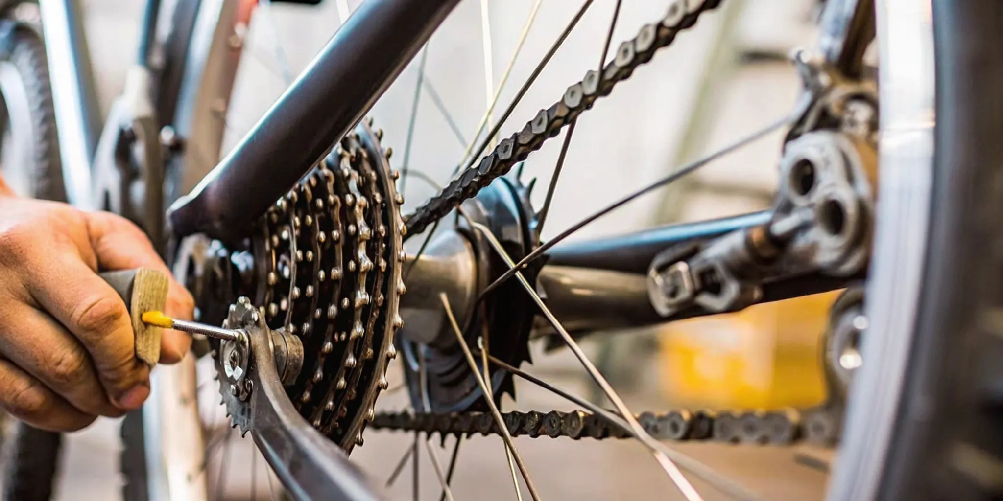 Technician lubricating an electric bike chain and drivetrain in a shop