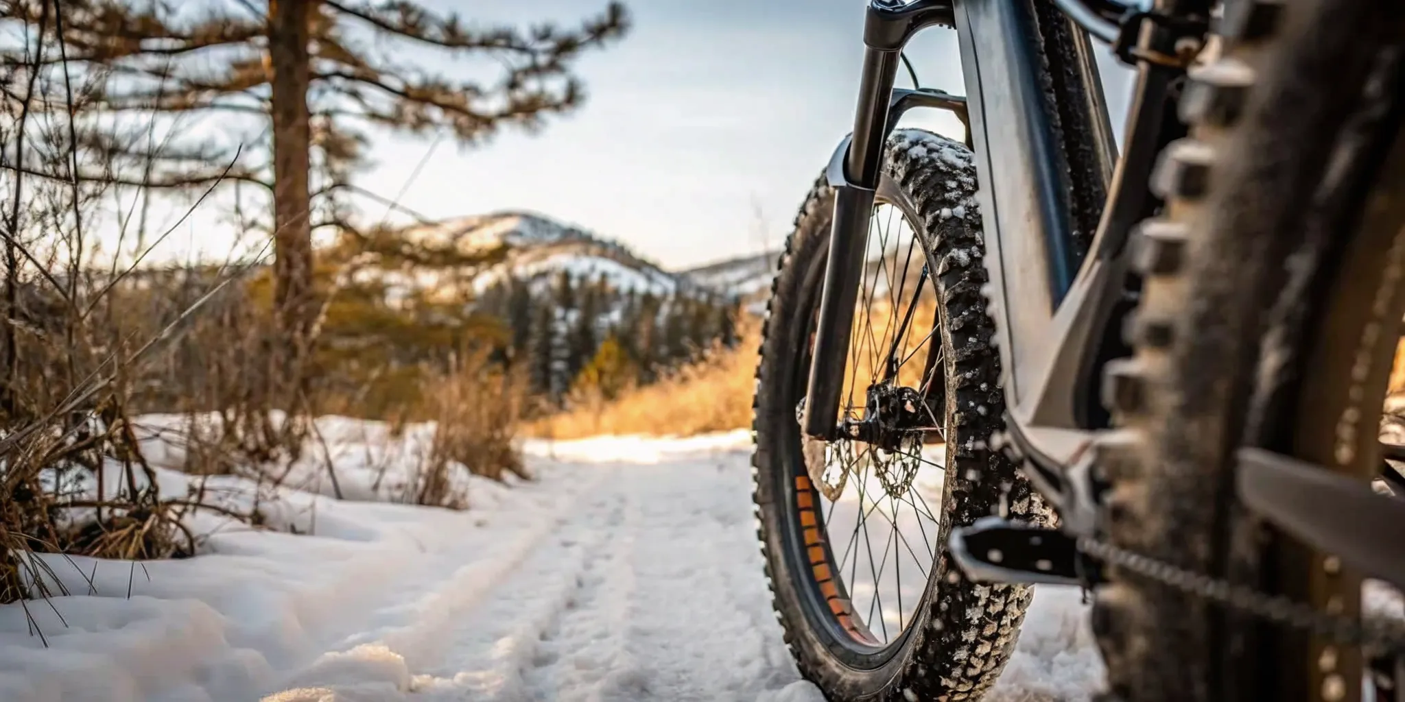 Electric snow bike track and front ski beside a snowy trail