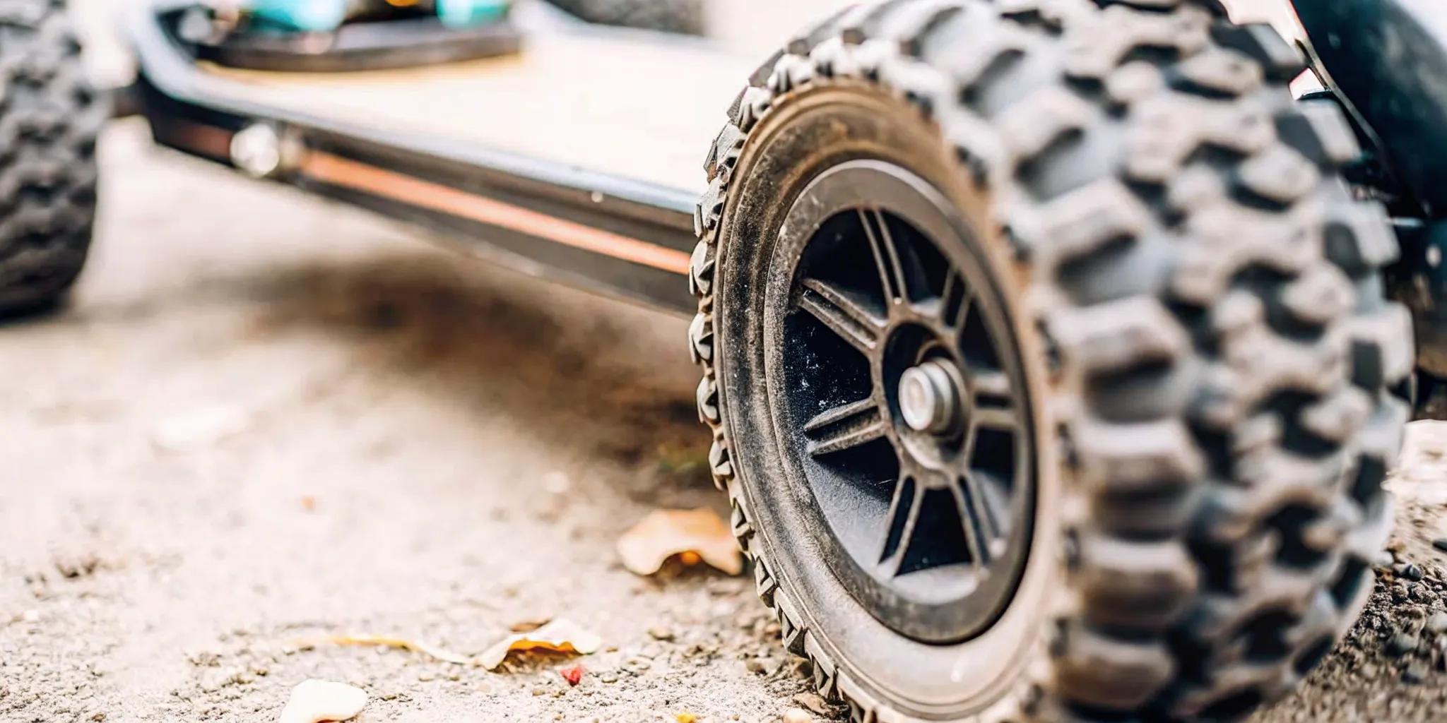Heavy-duty pneumatic off-road electric skateboard tires rolling over dusty mountain trails in Bend Oregon