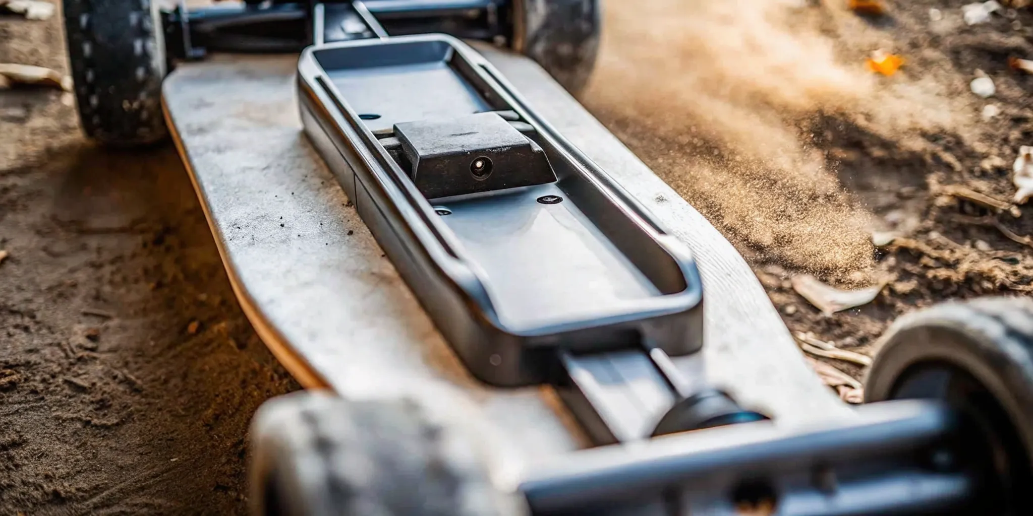 A swappable lithium battery pack being removed from an off-road electric skateboard deck on a trail