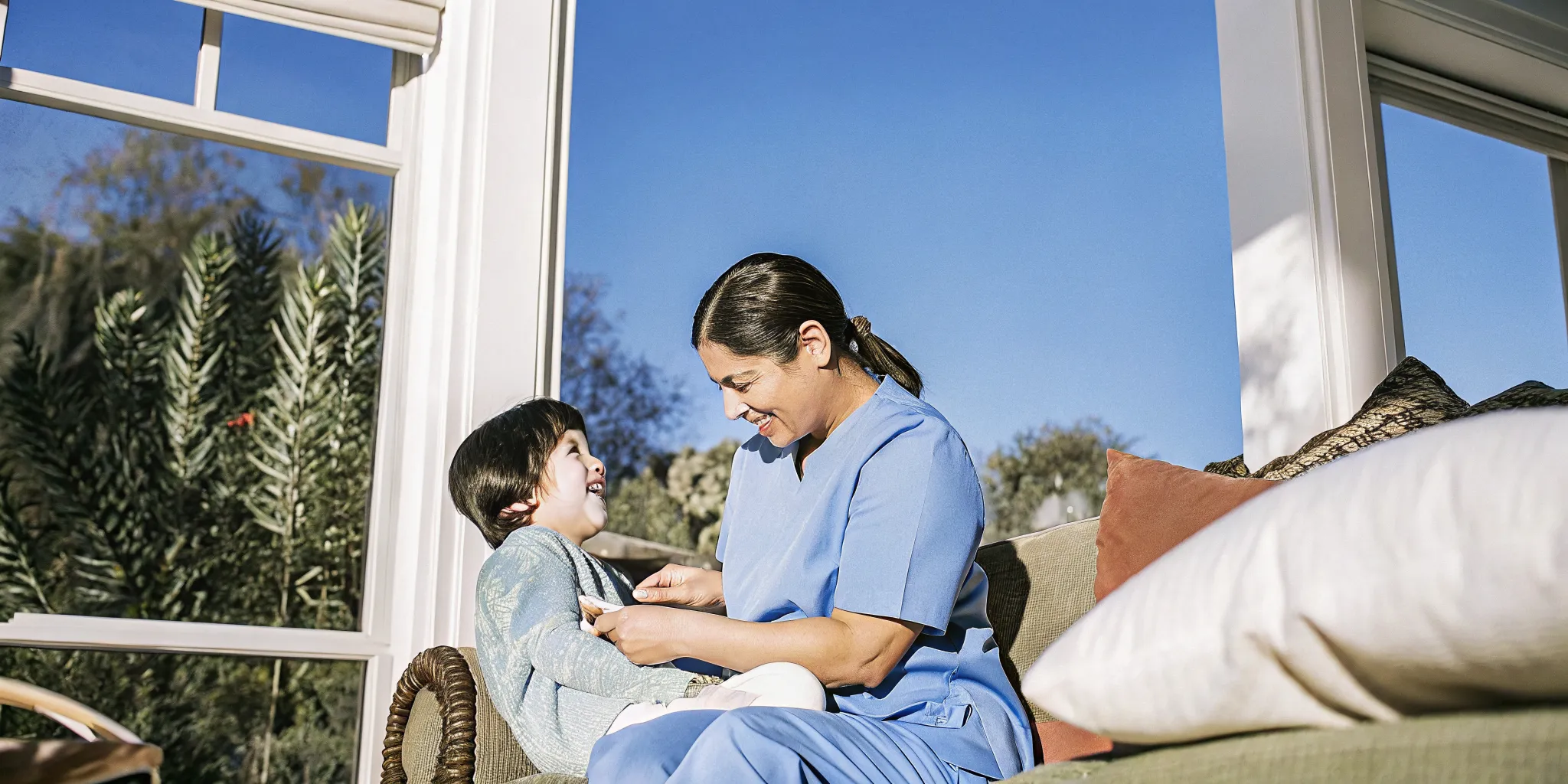 A pediatric home nurse checks oxygen levels on a child with Down syndrome while the child rests comfortably at home