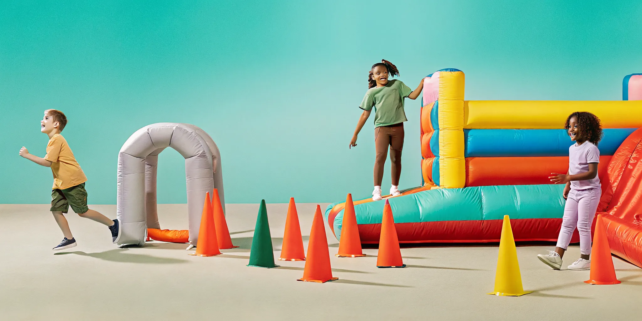 Students enjoying inflatable bounce houses and obstacle courses during a school field day event in Massachusetts.