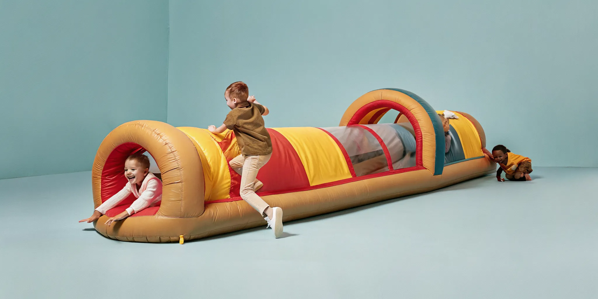 Children racing through a colorful inflatable obstacle course with tunnels and slides at a Massachusetts backyard party