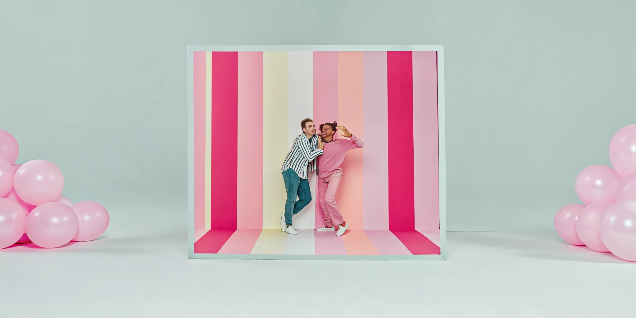 Guests posing and laughing inside a photo booth at a birthday party