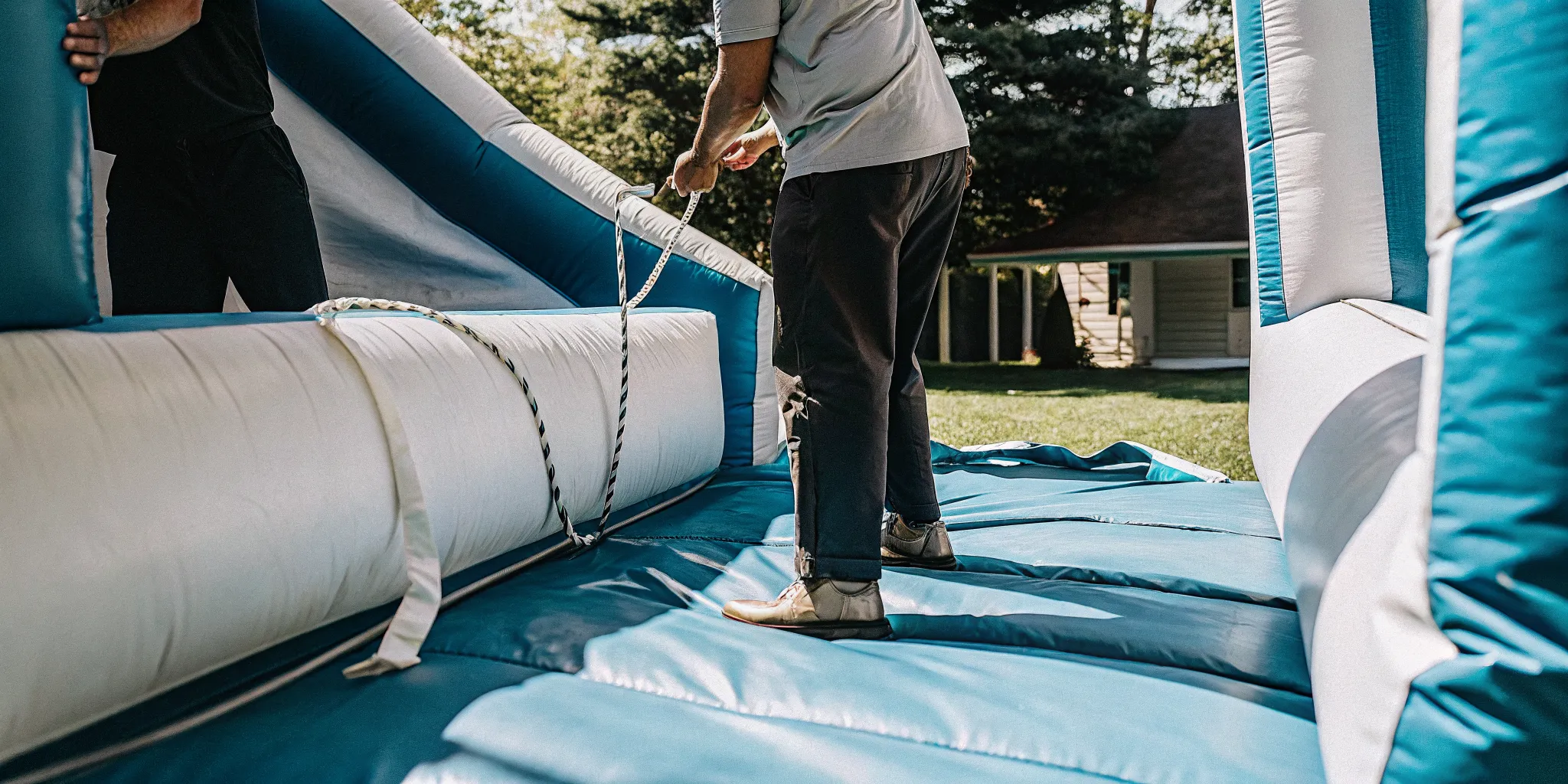 AJT Bounce professional staff securely anchoring an inflatable bounce house rental in Mansfield MA
