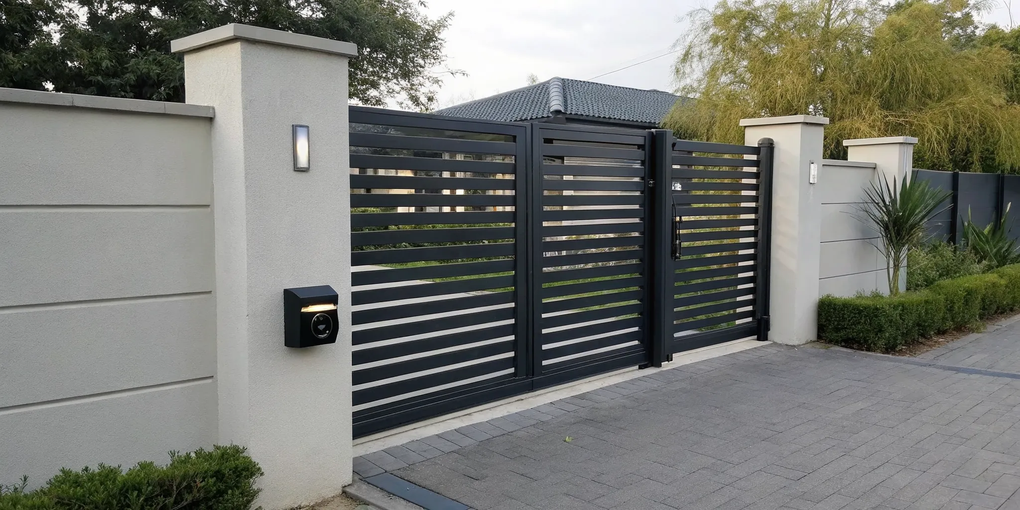 A gate intercom system installed on a modern driveway entrance.