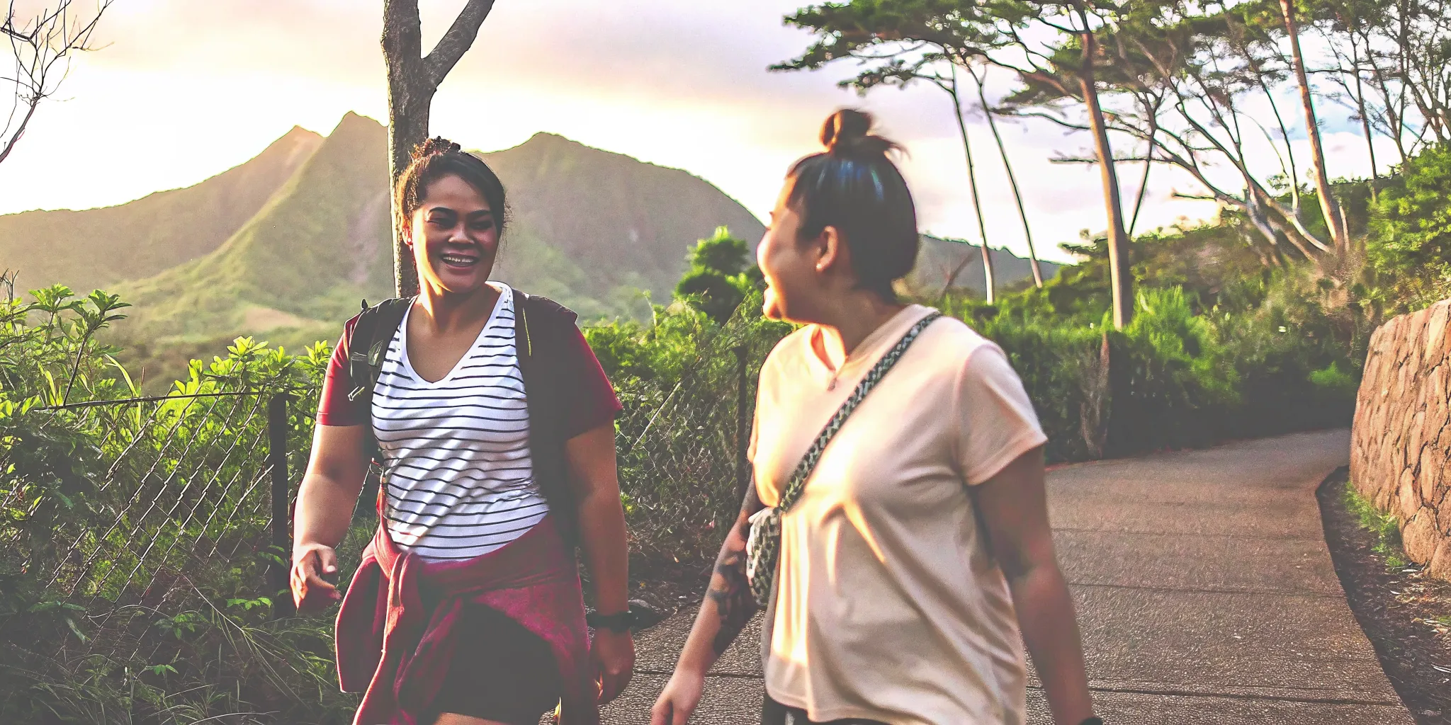 Two adults walking together on a Hawaiian trail during recovery-focused exercise