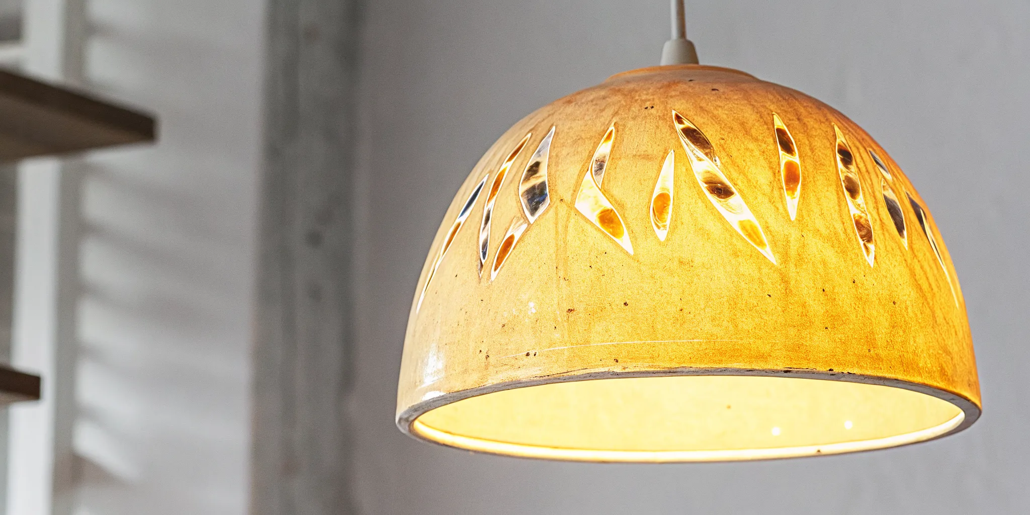 Handcrafted ceramic lamp shade with colorful glaze detail showing artisan texture and warm light
