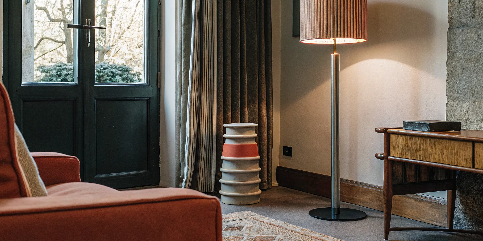 Layered living room lighting featuring a handcrafted color-blocked sculptural floor lamp and table lamp