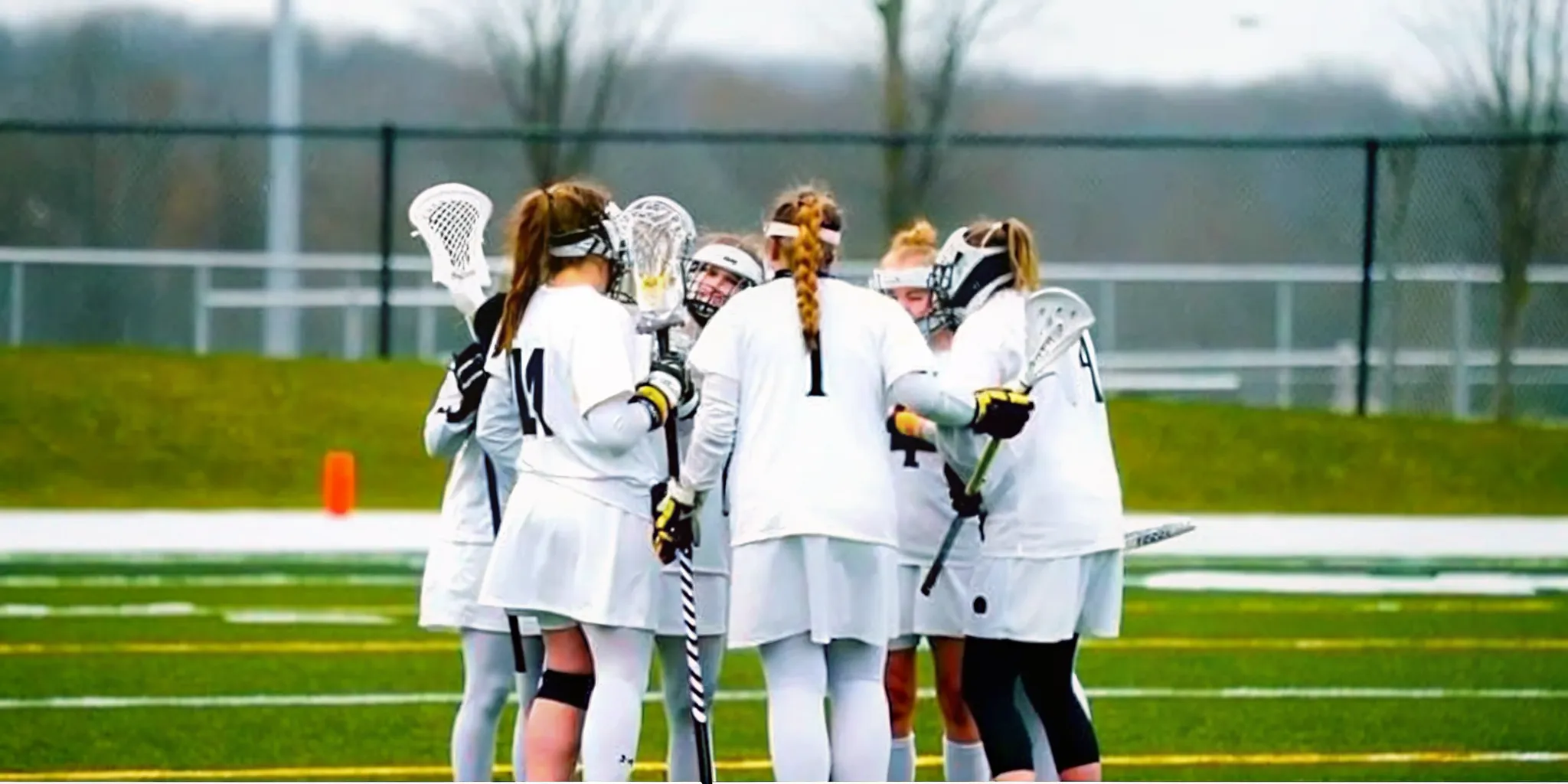 Girls lacrosse team wearing coordinated custom women's lacrosse uniforms