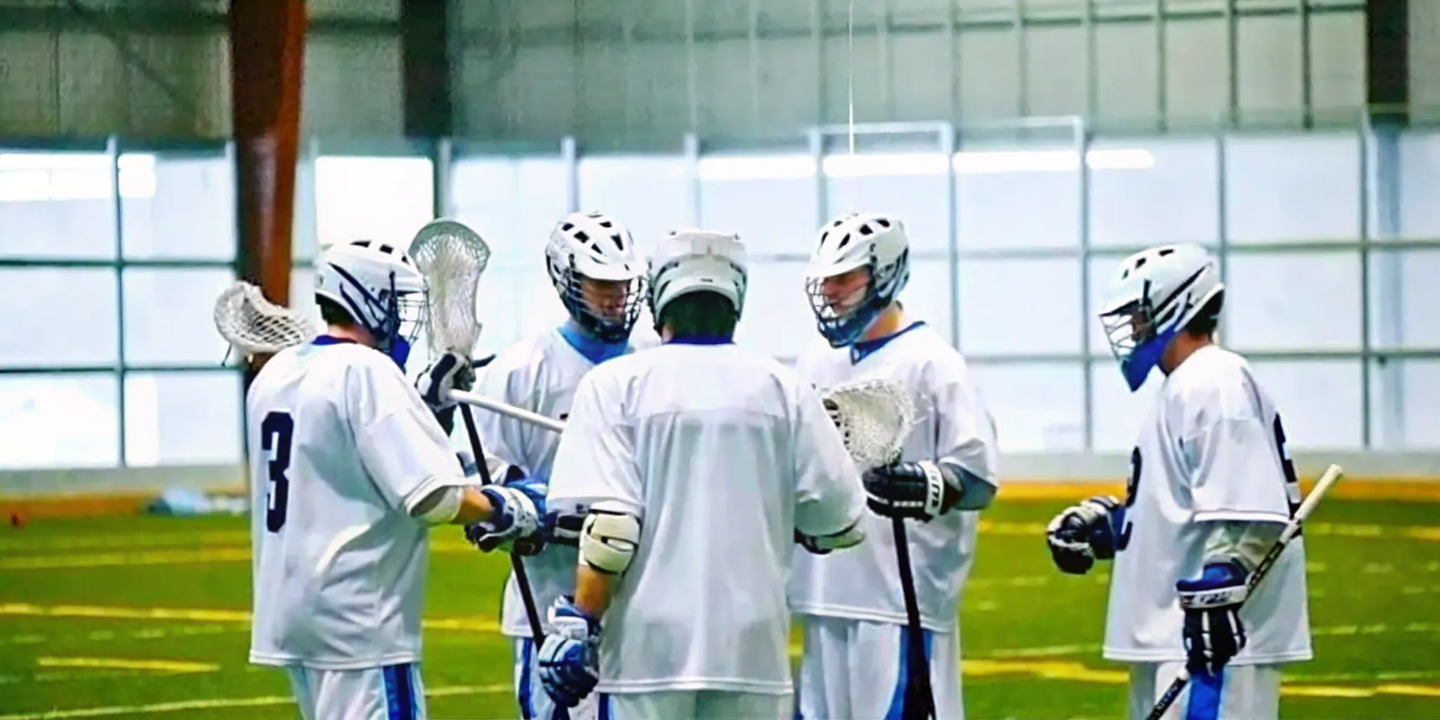 Box lacrosse players in coordinated custom team uniforms