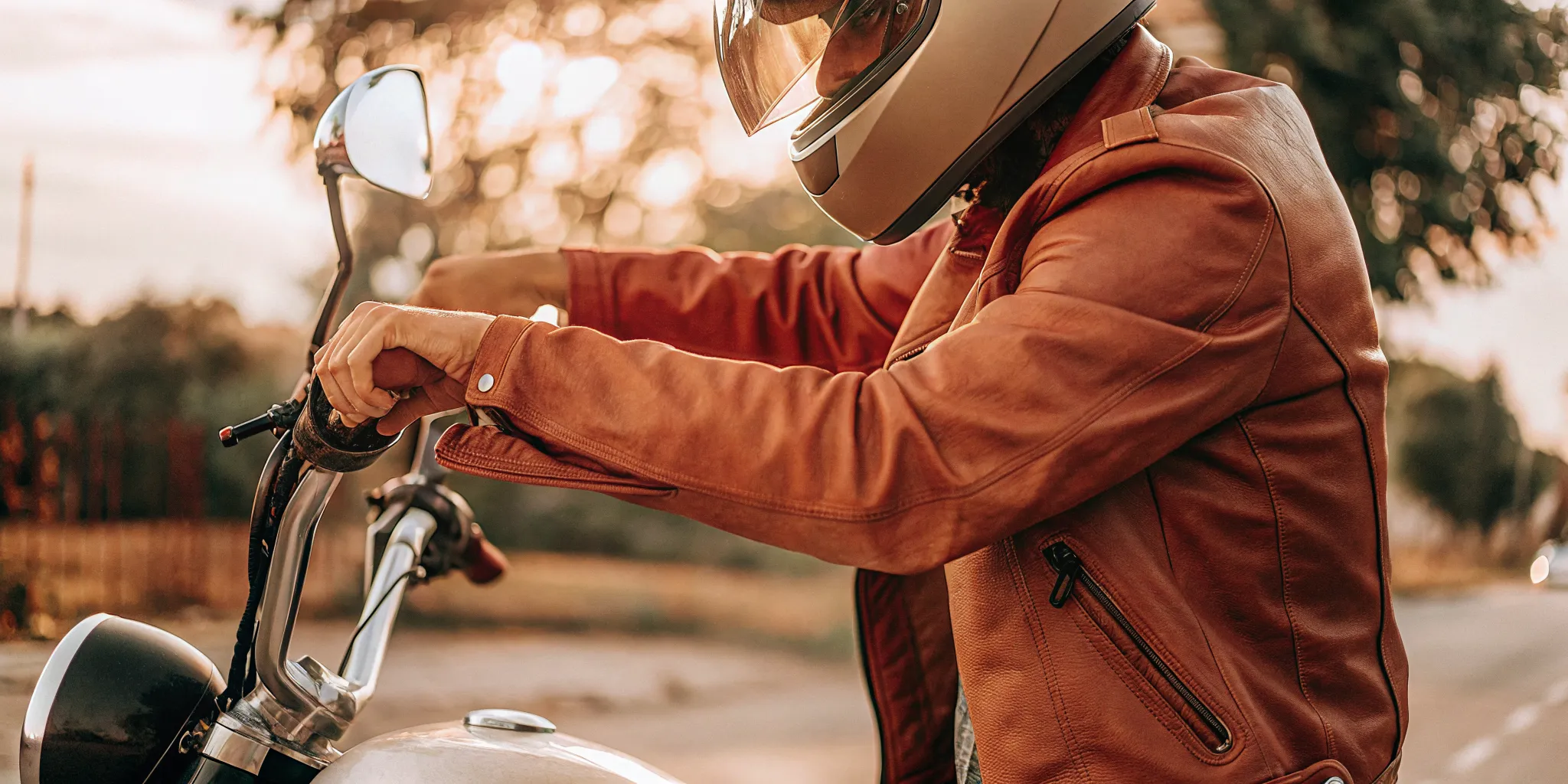 Rider securing a DOT-approved motorcycle helmet near a Florida roadway