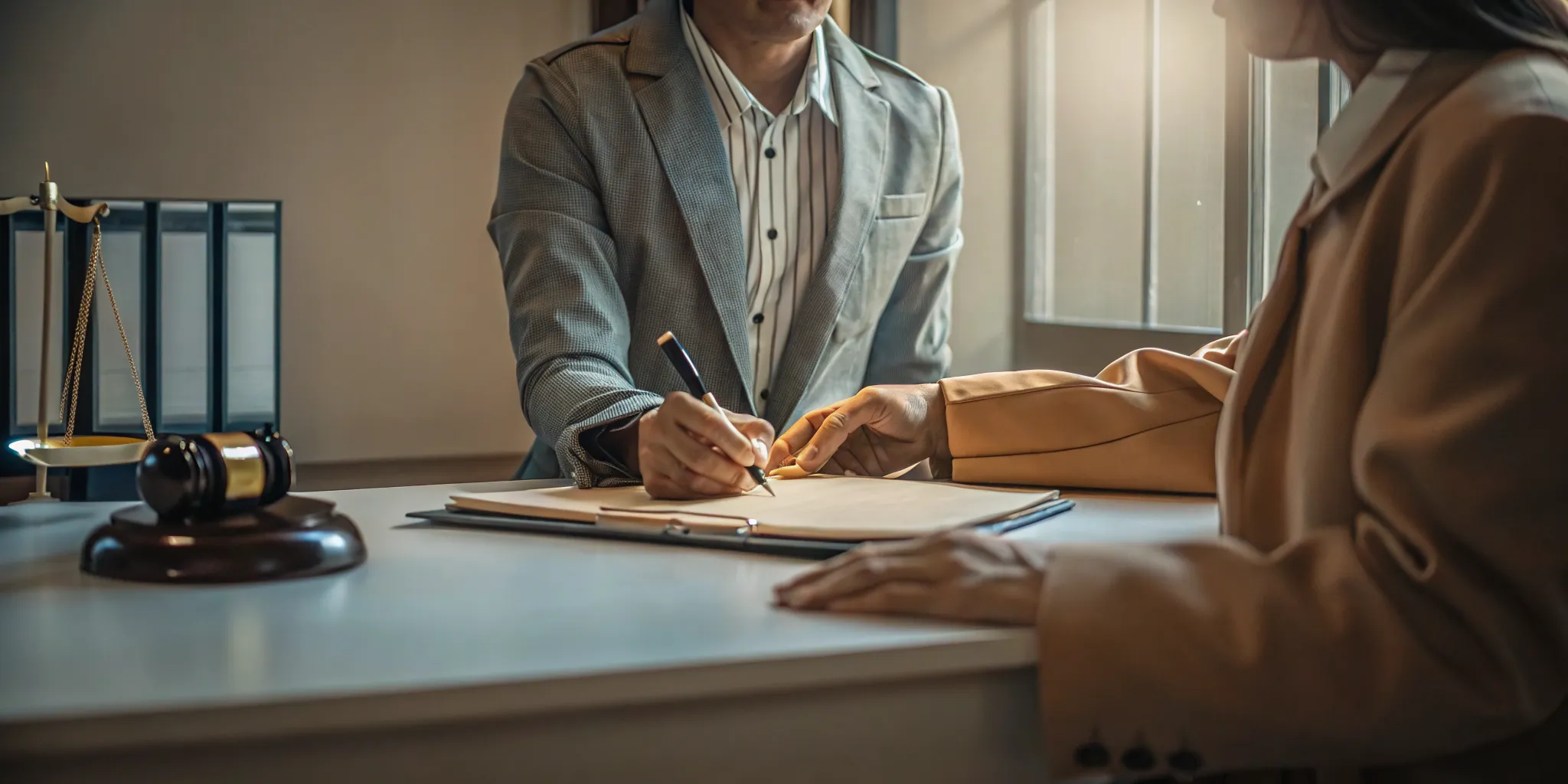 A person reviewing a bail bond indemnity agreement with a bail agent at a professional office desk