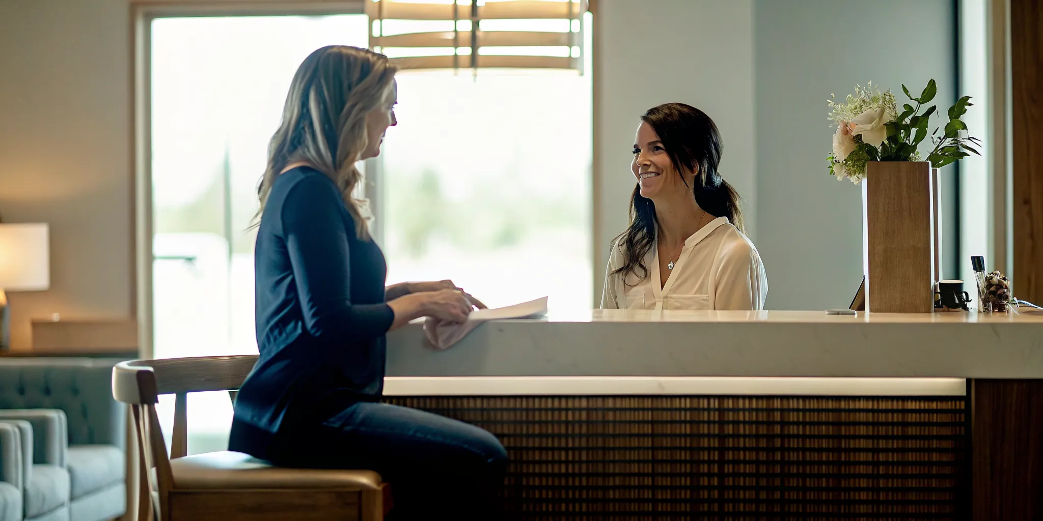 Med spa owner coaching a staff member one-on-one at the front desk