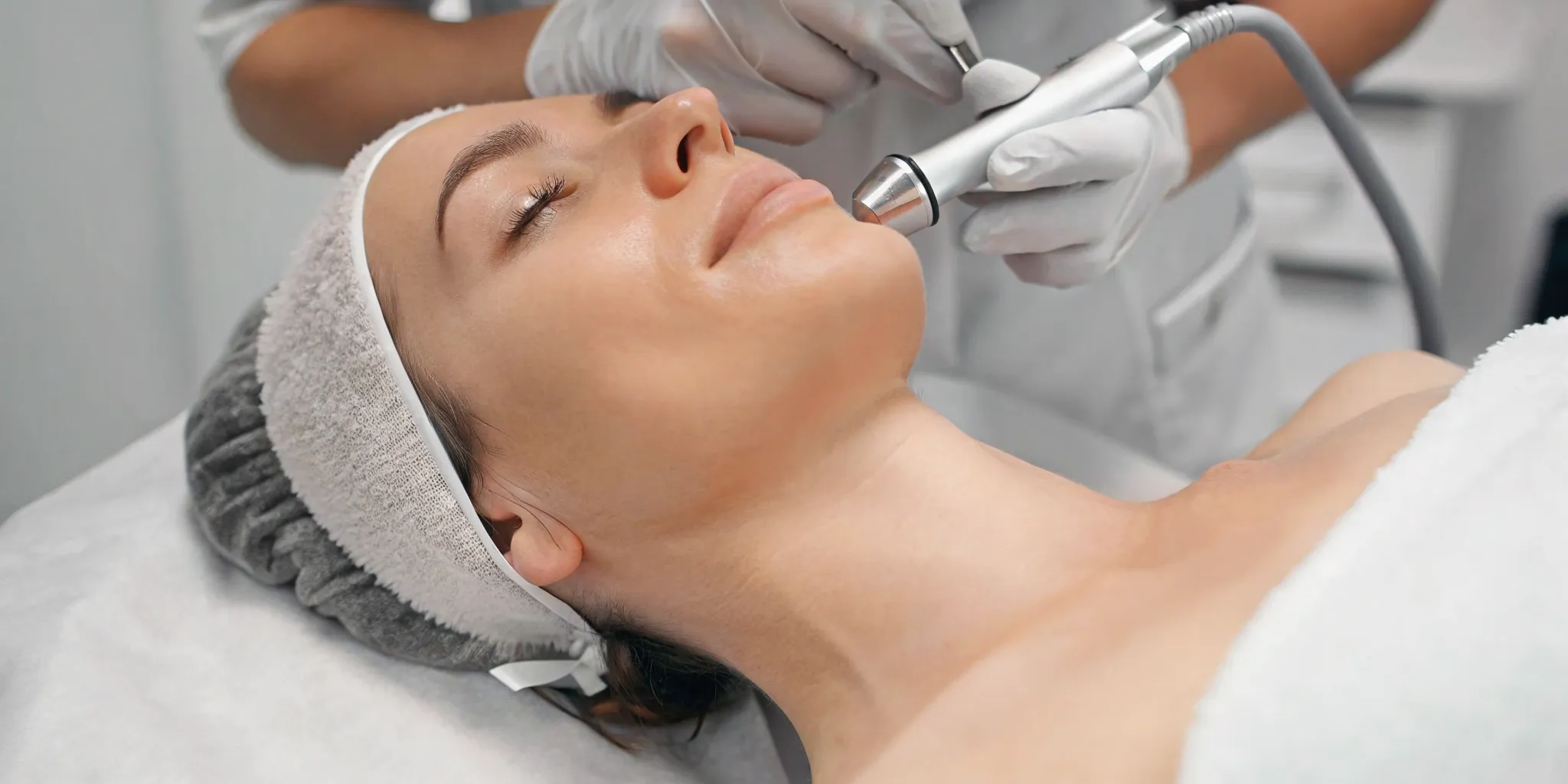 Close-up of a HydraFacial tip exfoliating and deep cleansing a client's cheek for smooth, glowing skin