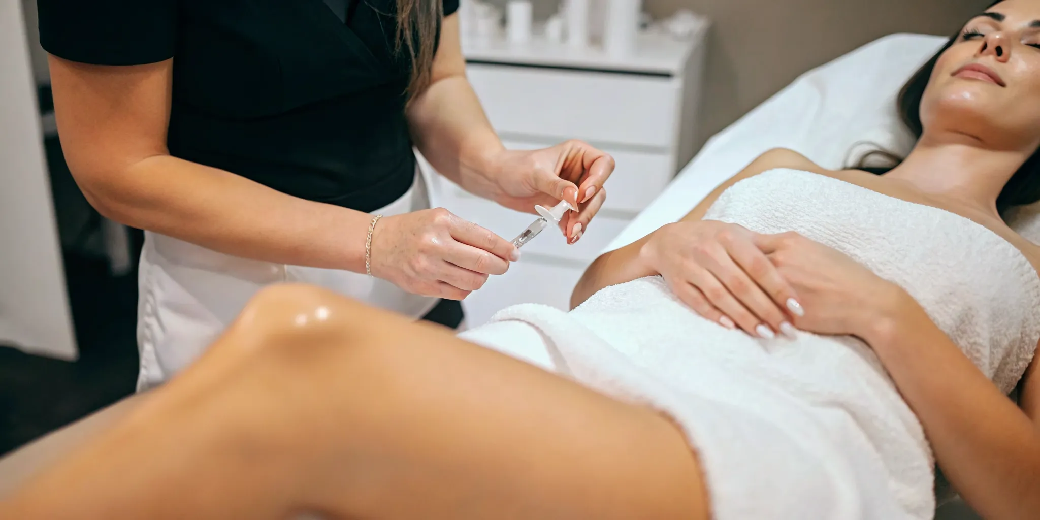 Aesthetic provider preparing a dermal filler injection for a relaxed patient in a Dallas med spa treatment room