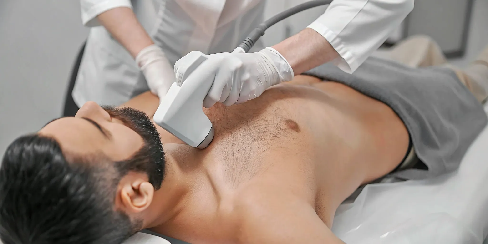 Licensed professional performing laser hair removal for a man's back and shoulders