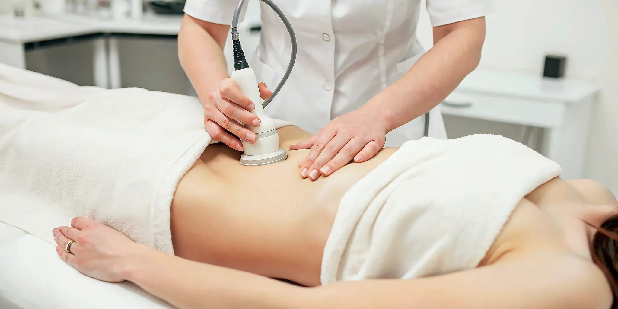 Medical spa treatment room with UltraShape body contouring device and treatment bed