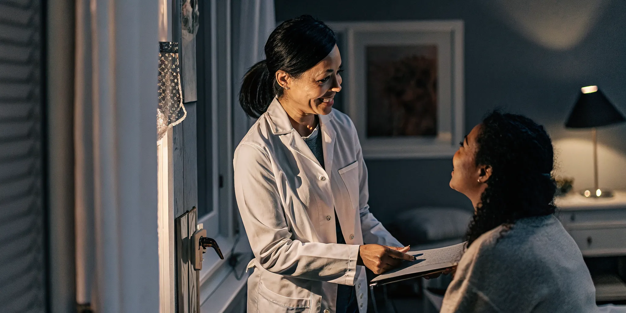 A professional health insurance consultant having a warm client consultation in a modern bright medical facility