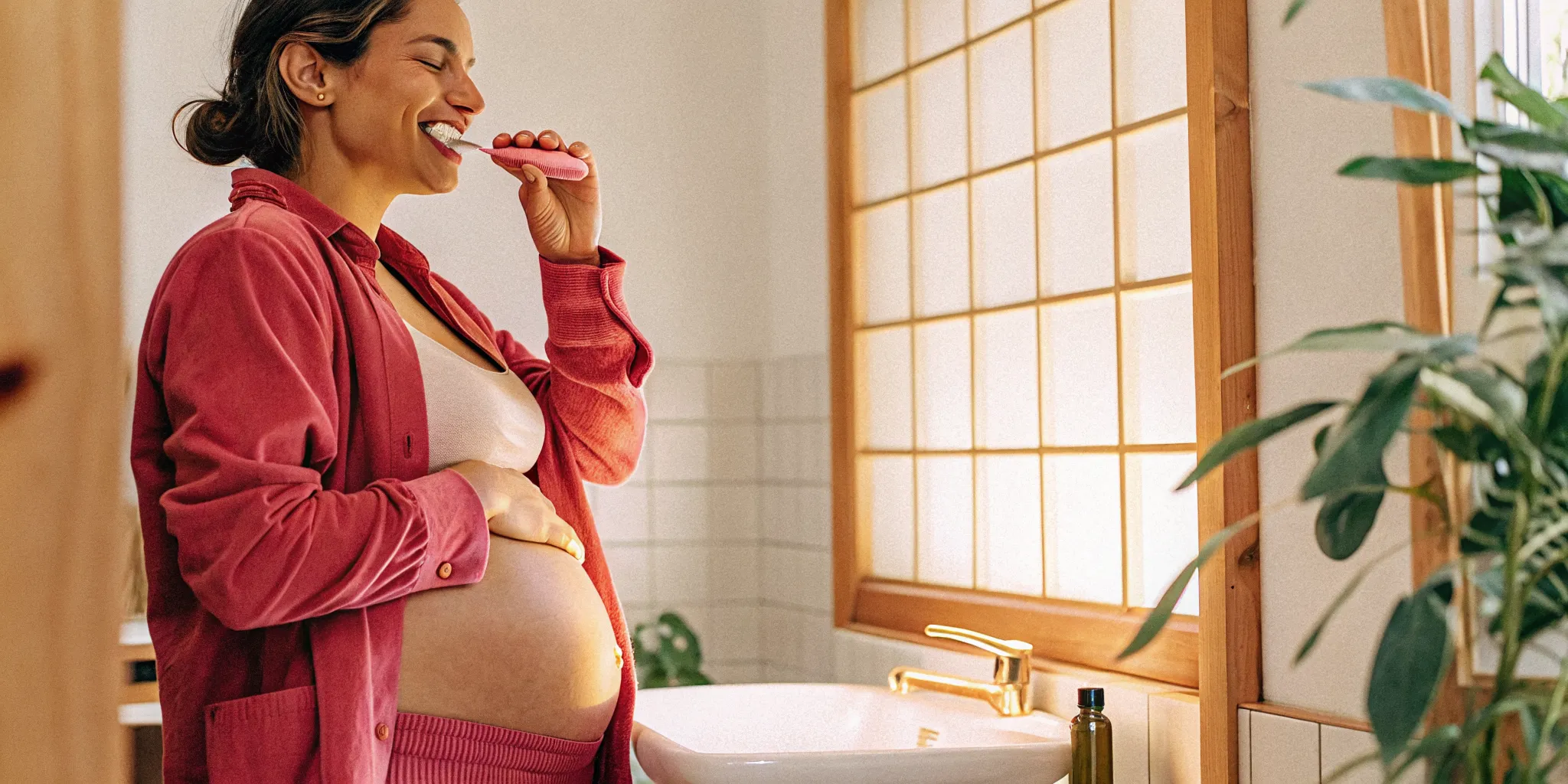 Pregnant woman brushing her teeth at home to protect her smile during pregnancy