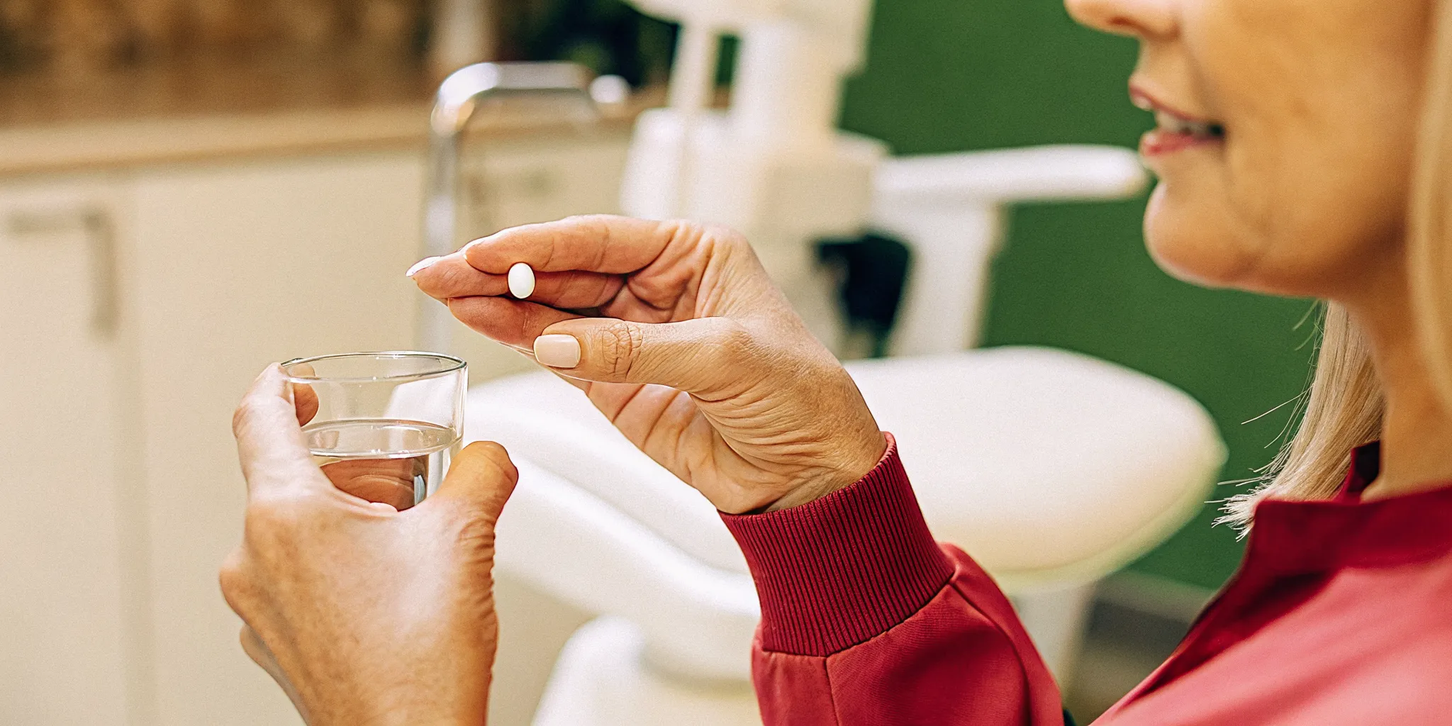 Dental professional holding oral conscious sedation pill and glass of water in a calm Hillcrest dental office