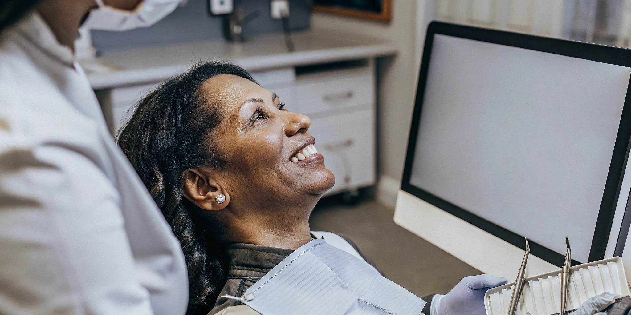 Smiling patient showing healthy healed dental implants with confident bright smile in San Diego dental office