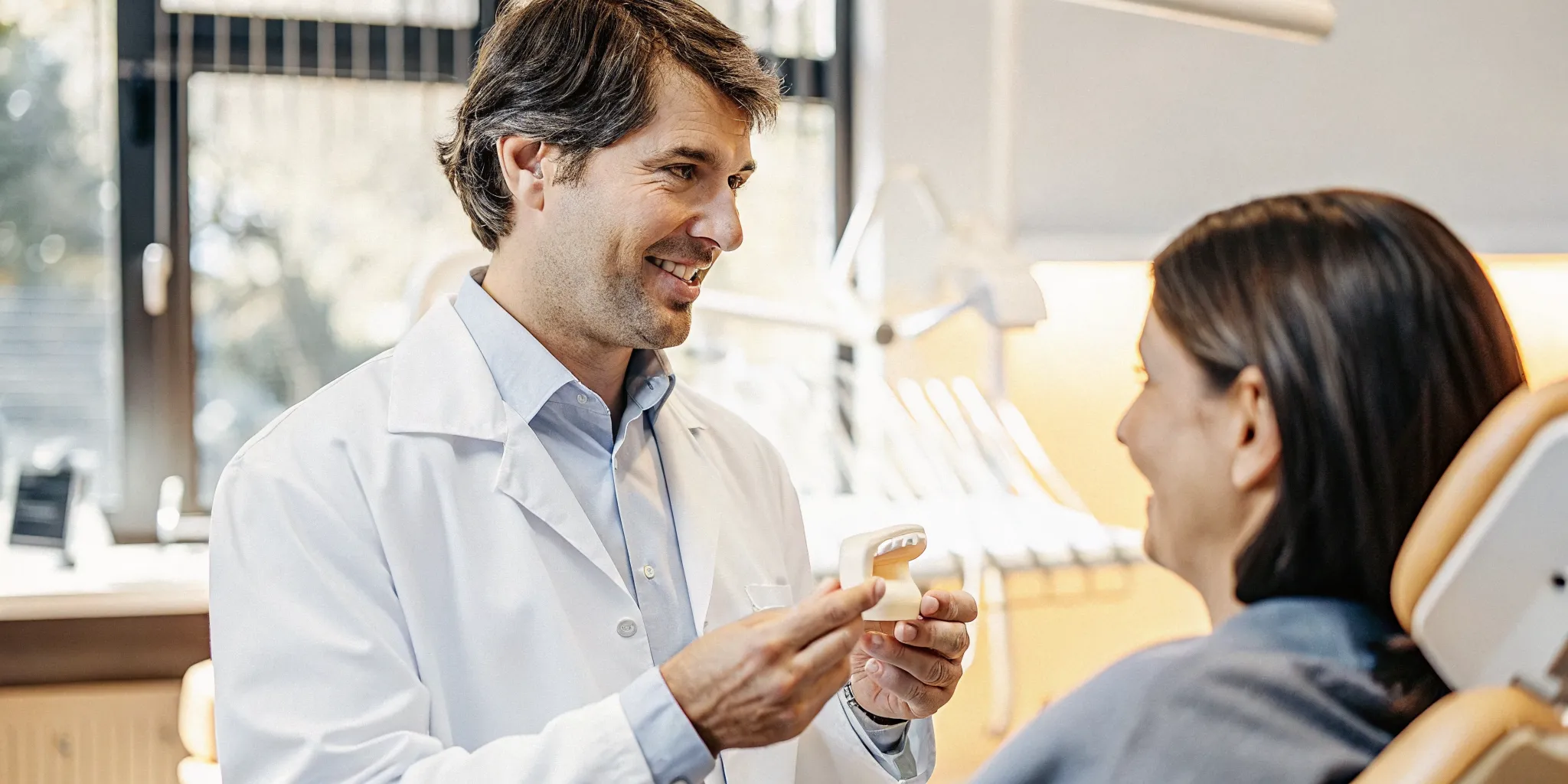 Dentist showing a patient how to care for a restored tooth after root canal treatment