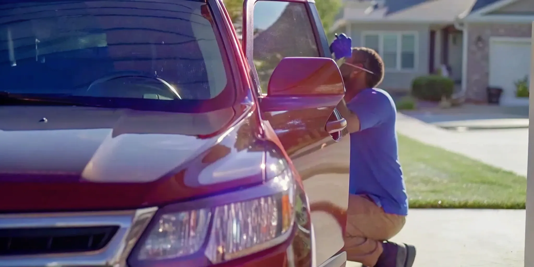 Mobile technician installing a windshield replacement on a vehicle in a Kansas City driveway