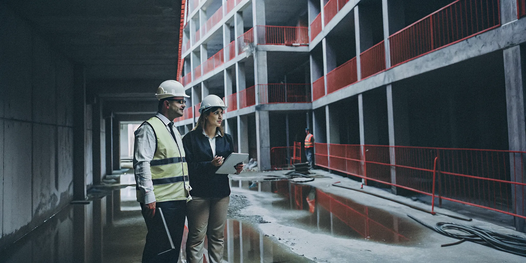 Workers in safety gear on a construction site, a guide on how to report an unsafe site.