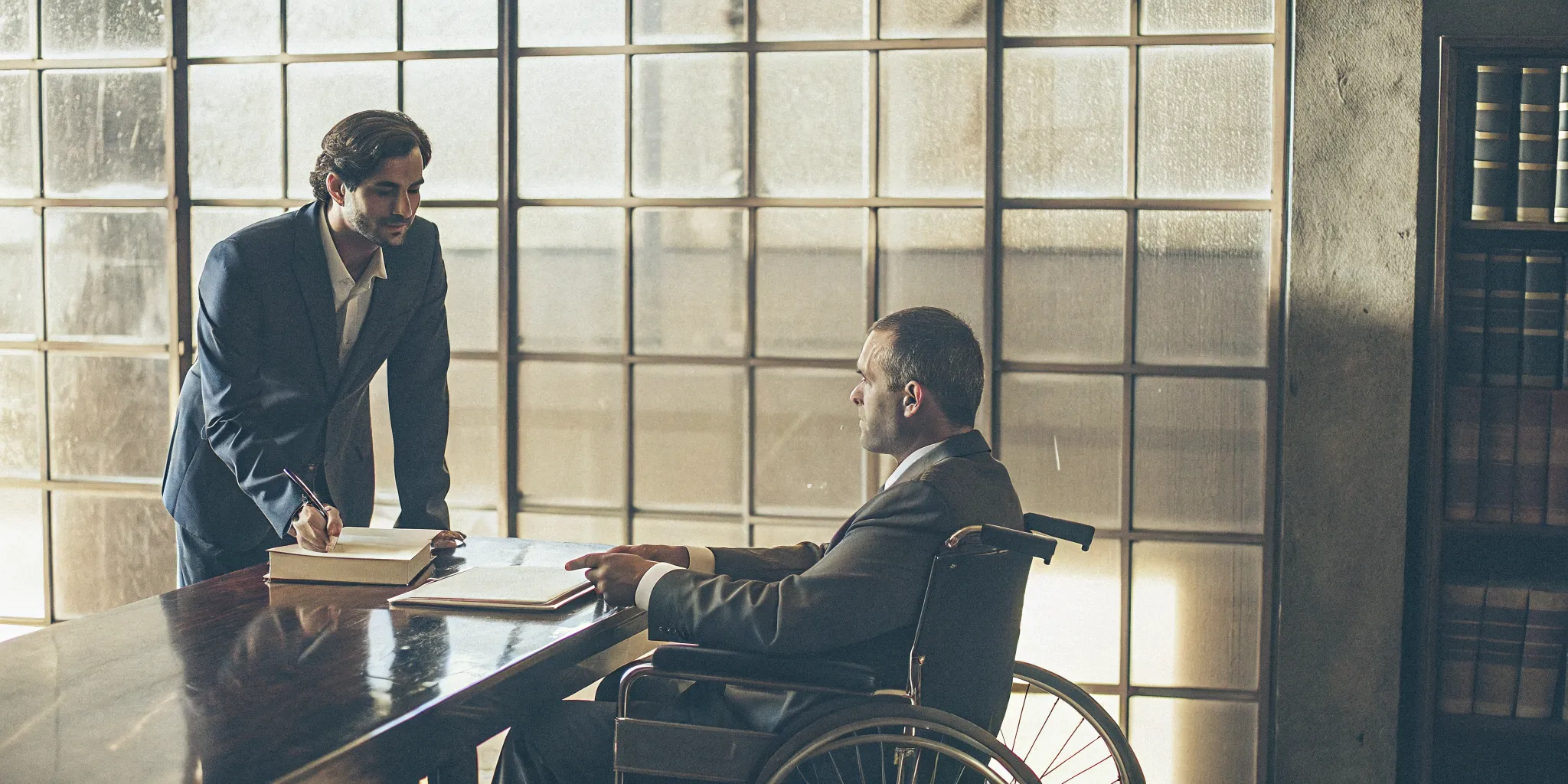 A man in a wheelchair discusses his case with the ERISA disability attorney he hired.