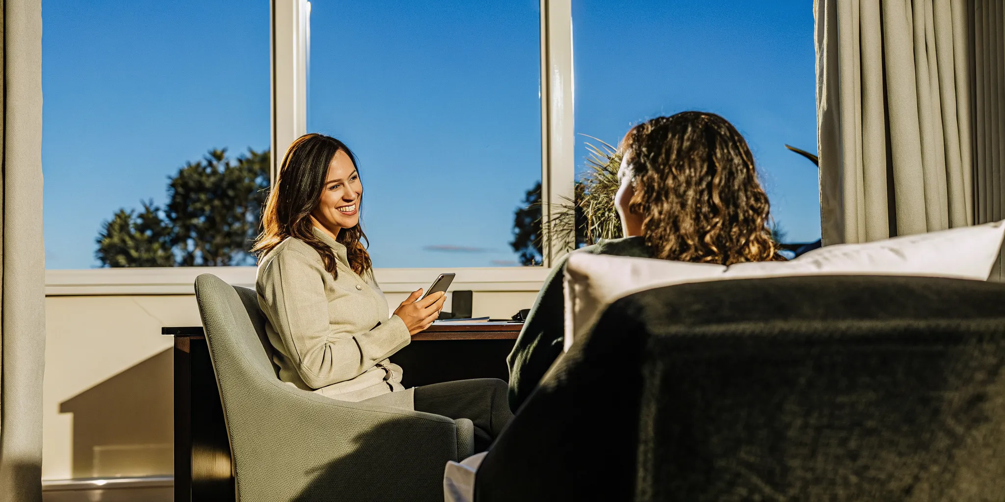 A CenterPointe staff member on the phone warmly reviewing an Aetna insurance benefits check with an adult client