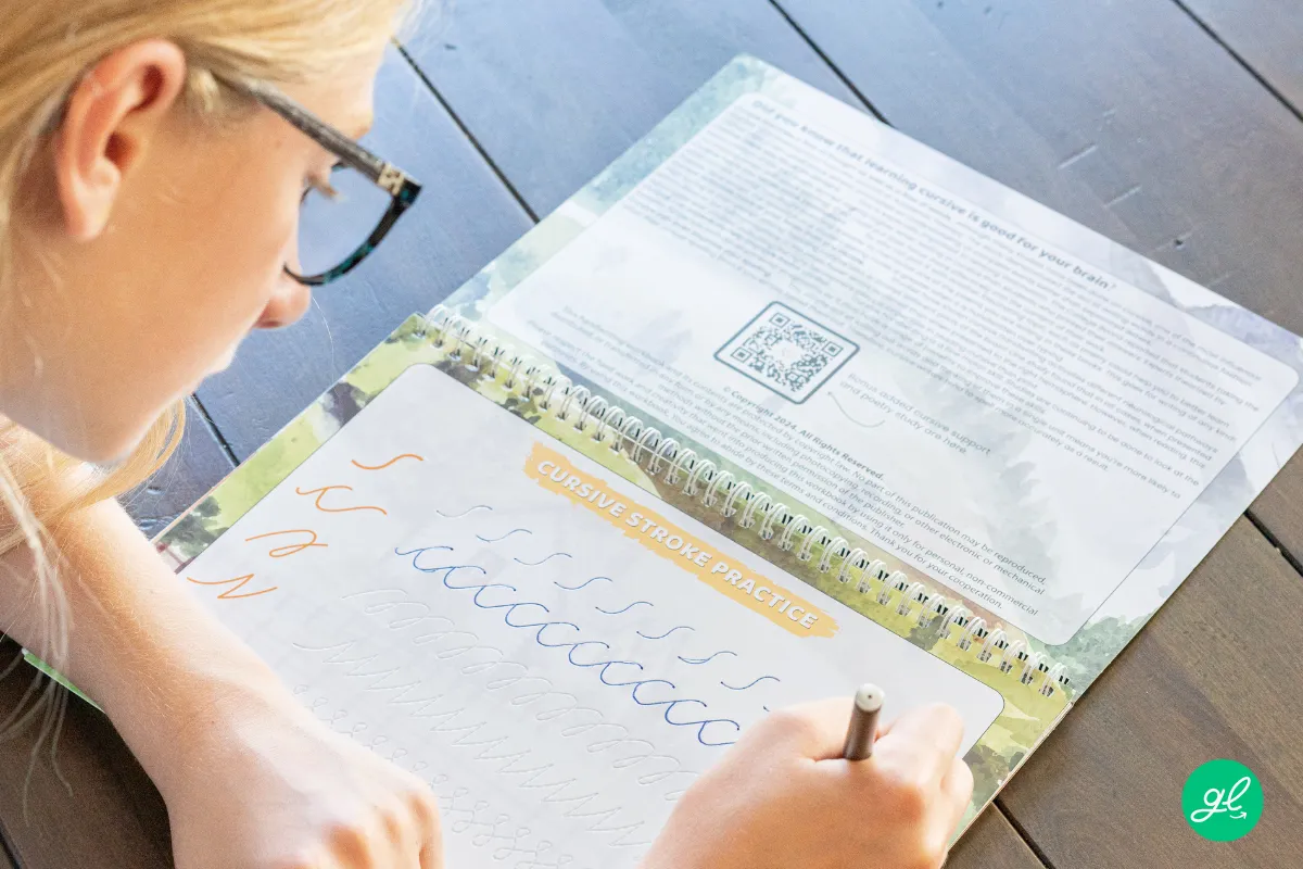 Parent guiding a child's pencil control during cursive handwriting practice