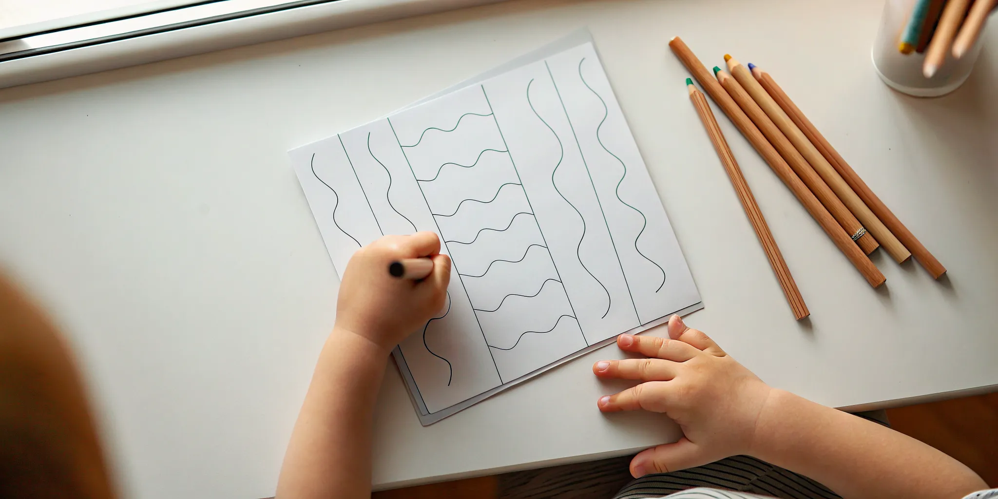 Child comparing print and cursive handwriting practice