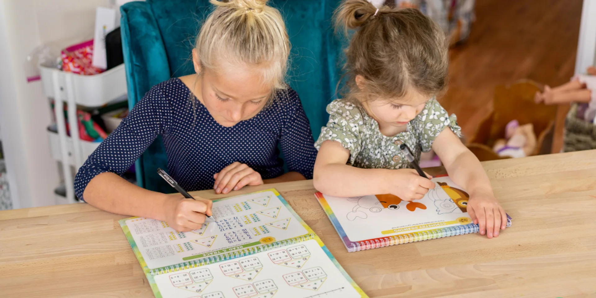 A child practicing handwriting and letter sounds on a grooved learning workbook with disappearing ink.
