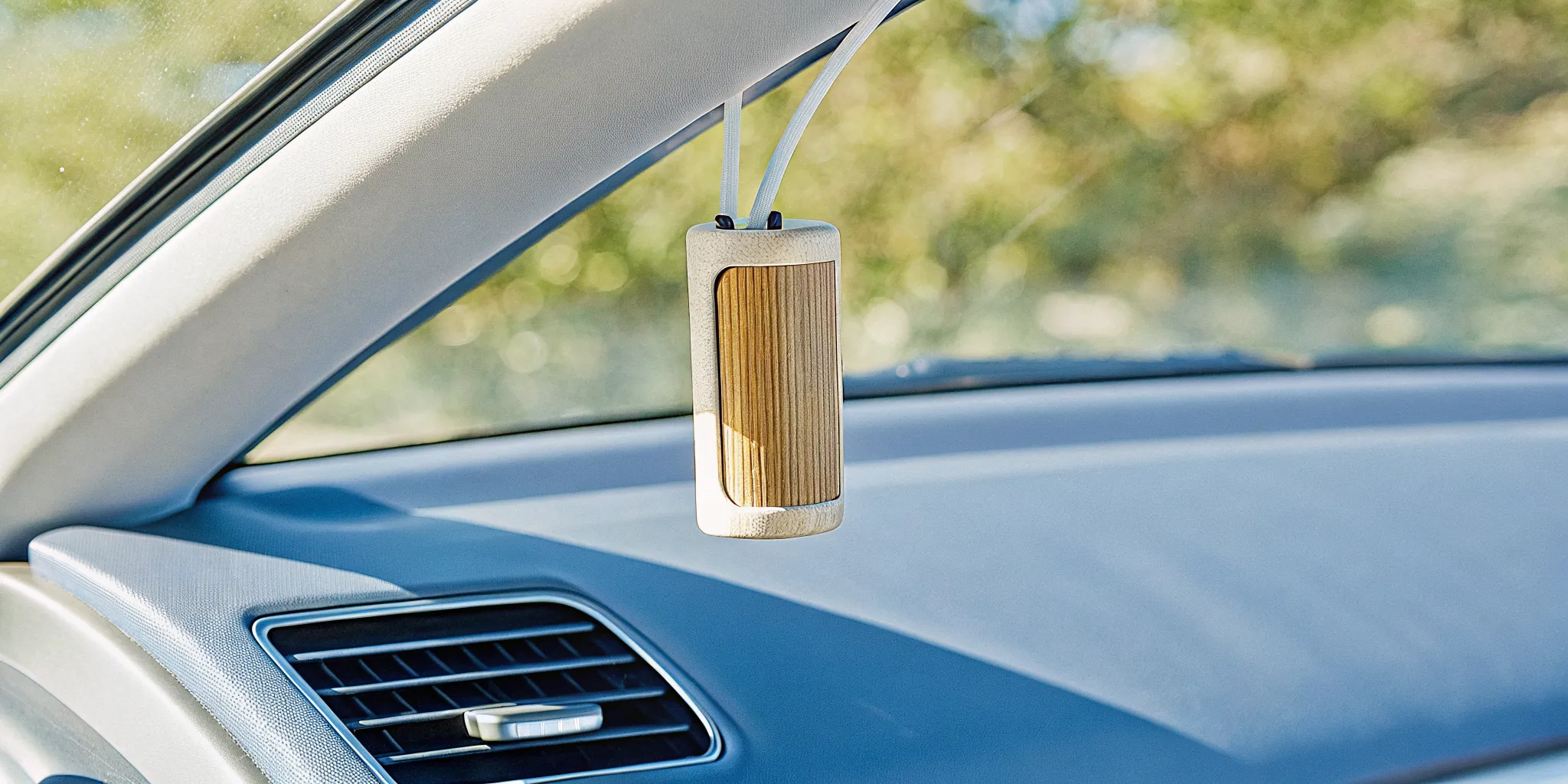 Minimalist refillable wood car scent diffuser in a clean car interior