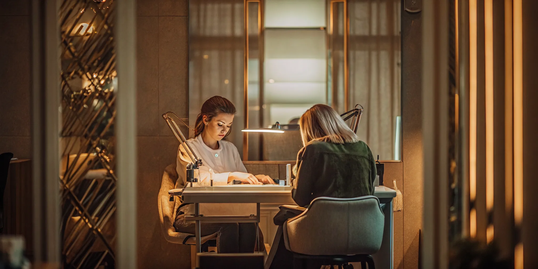 Experienced nail technician working at an organized manicure station in a private suite